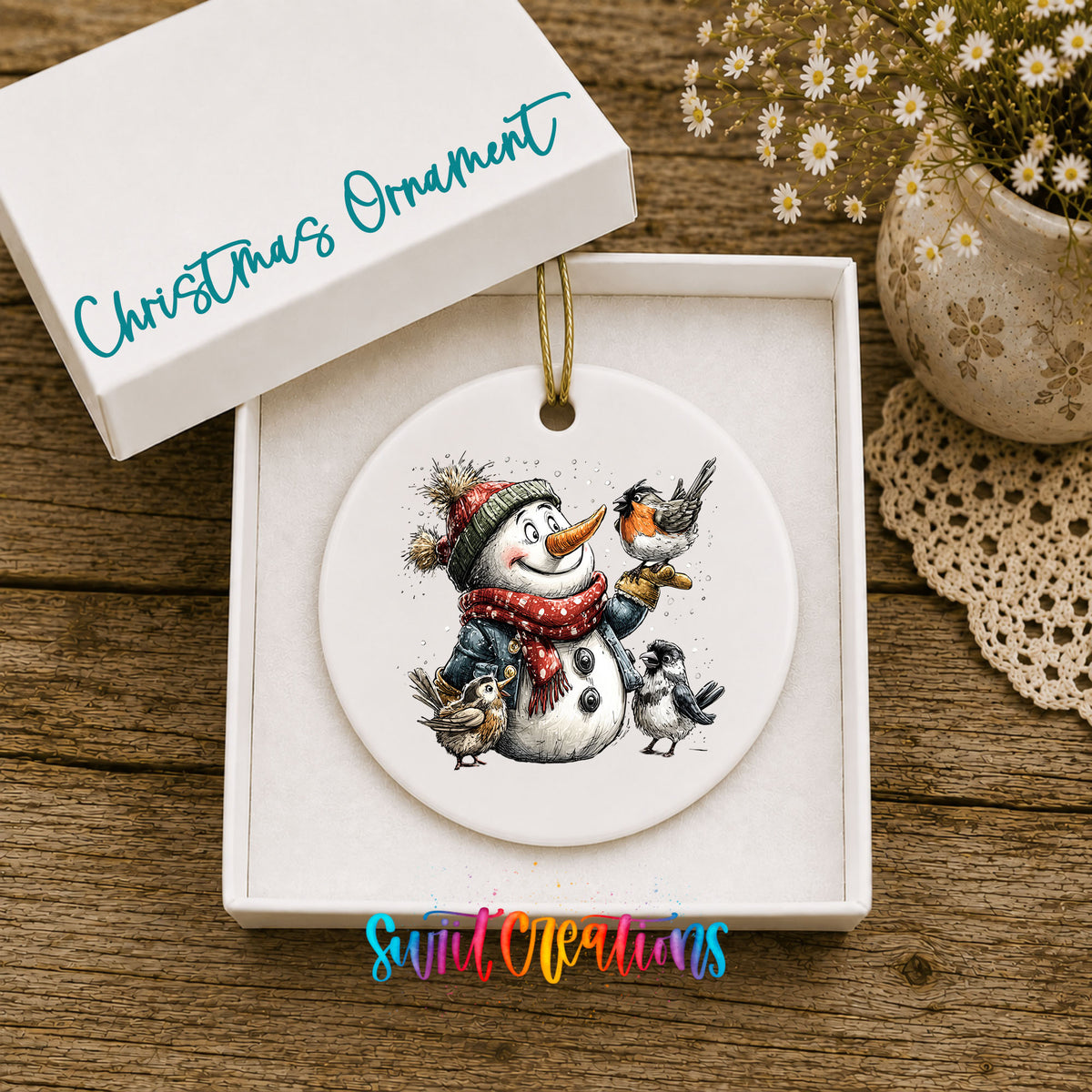 snowman in a red scarf surrounded by birds ceramic Christmas ornament presented in a gift box