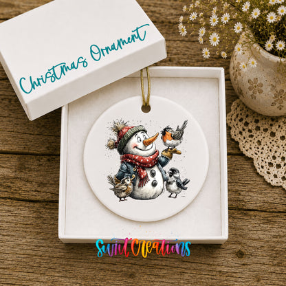 snowman in a red scarf surrounded by birds ceramic Christmas ornament presented in a gift box