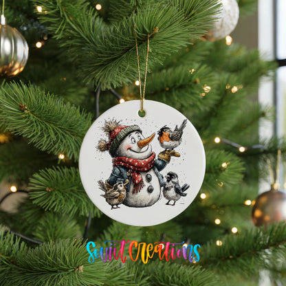 snowman in a red scarf surrounded by birds ceramic Christmas ornament hanging on a lit Christmas tree