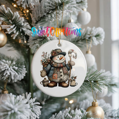 snowman in a brown winter hat holding a candy cane ceramic Christmas ornament hanging on a frosted Christmas tree