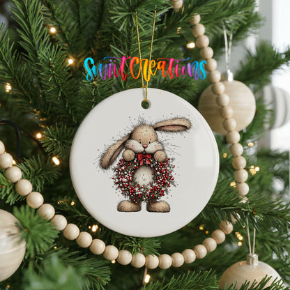 woodland rabbit holding a red berry wreath ceramic Christmas ornament hanging on a green Christmas tree