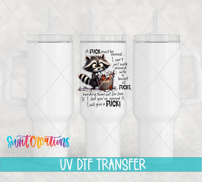 A F*ck Must Be Earned Raccoon UV DTF transfer applied to a white tumbler set from Swiit Creations