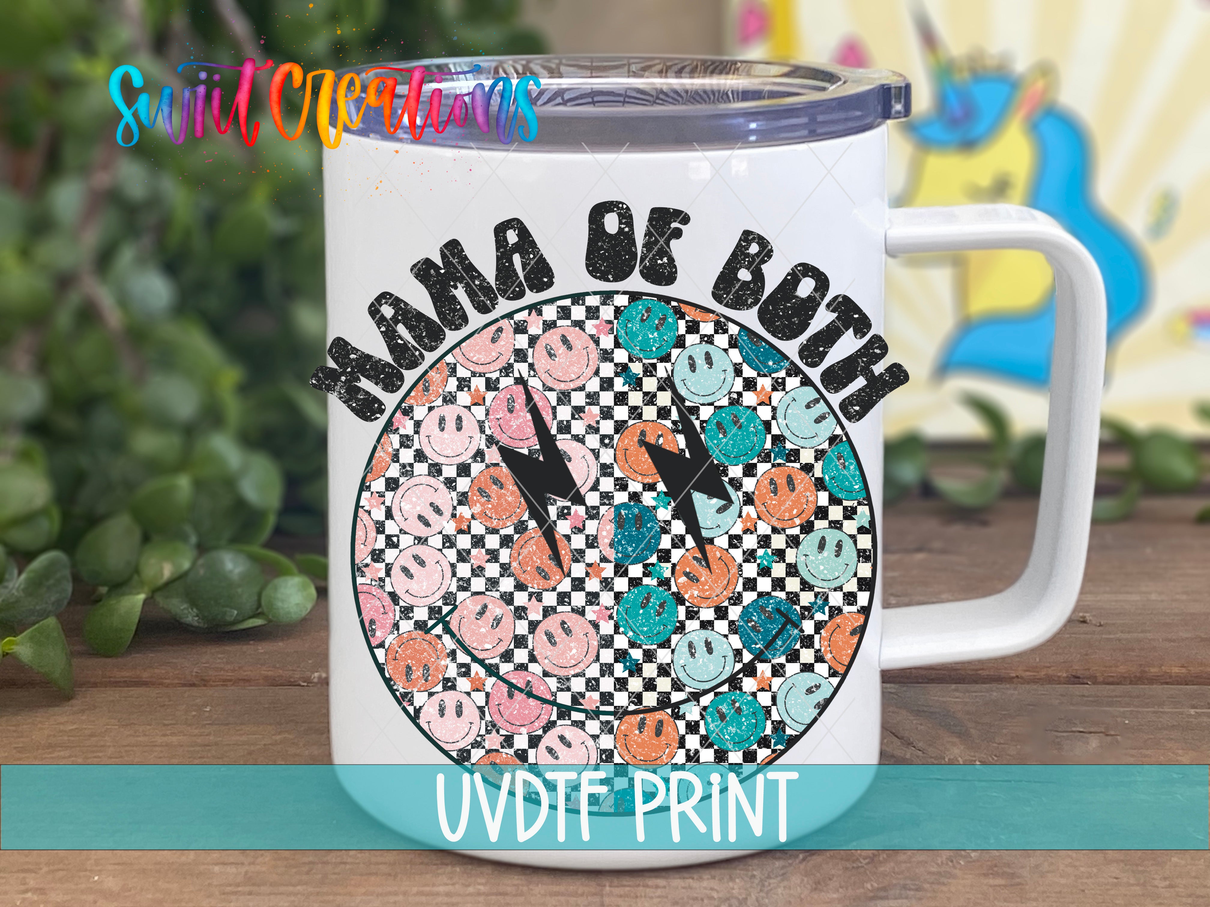 A white mug with a colorful graphic design featuring a checkerboard pattern of smiley faces and the text "MAMA OF BOTH" printed on it.
