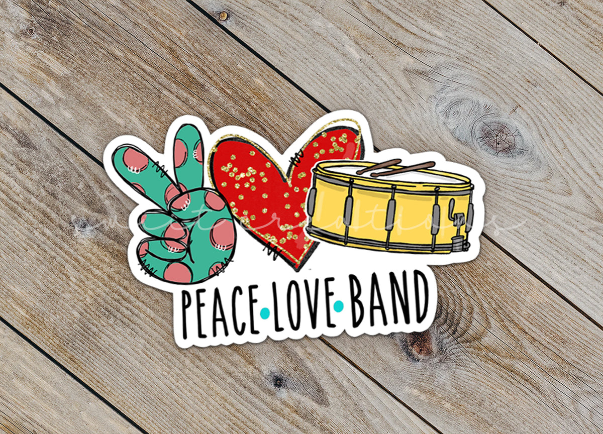 a peace love band sticker sitting on top of a wooden table