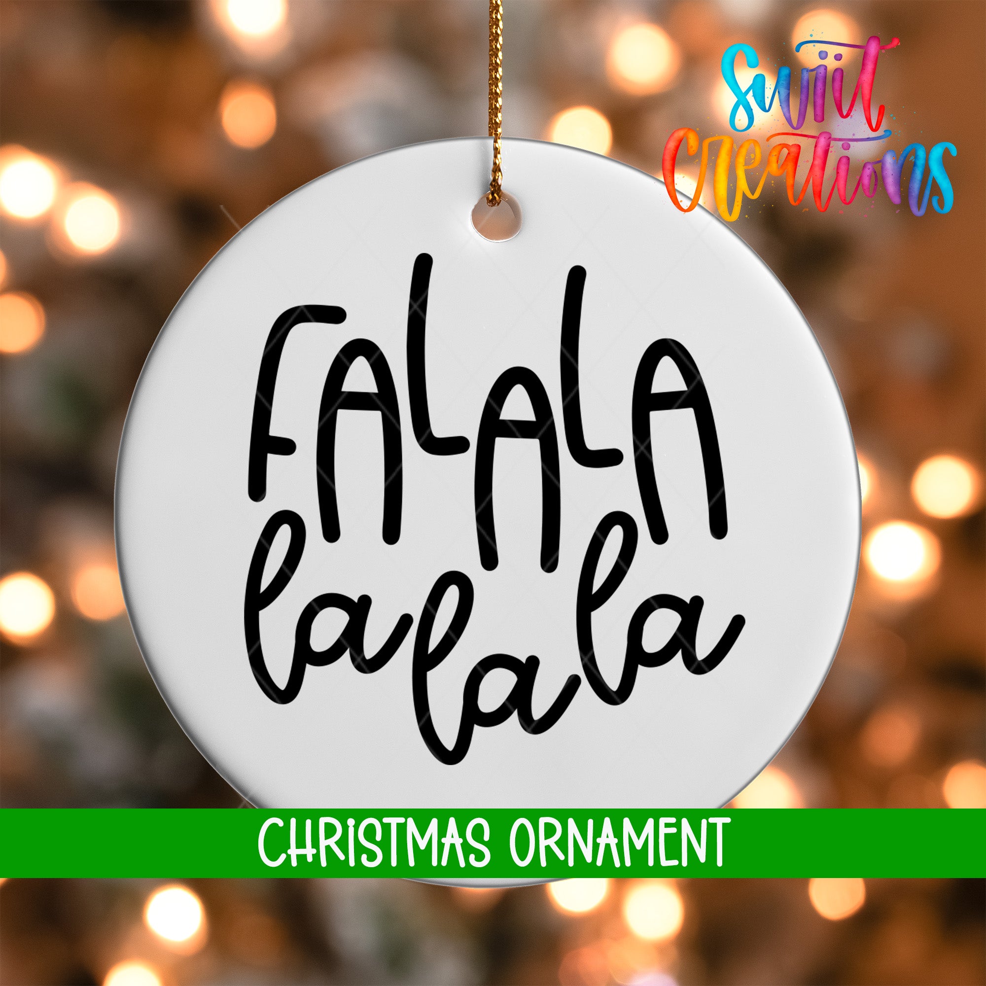 A white Christmas ornament with the text "FALA" and "LA LA LA" written on it, hanging against a background of colorful lights.