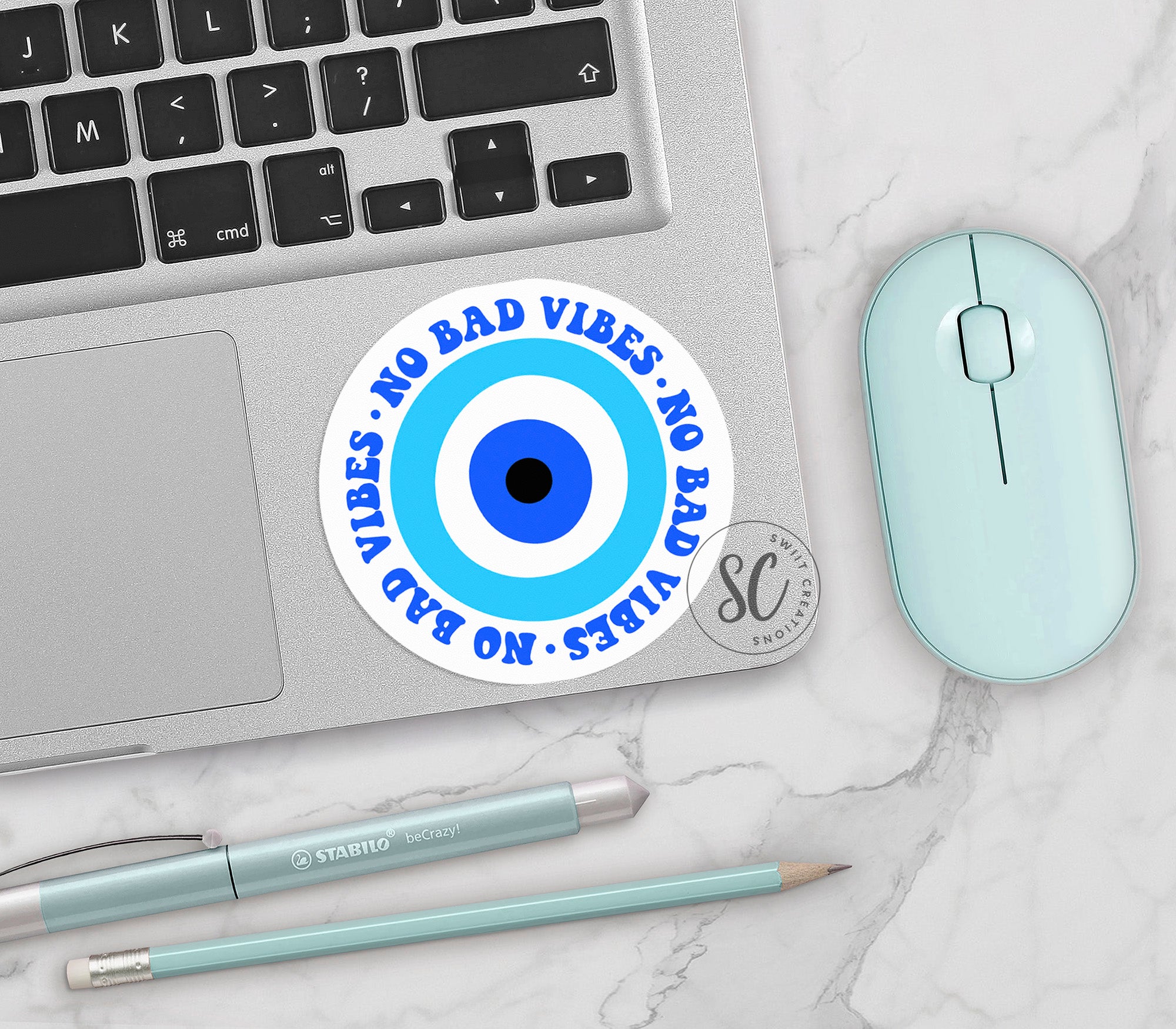 a computer mouse, keyboard, and sticker on a table