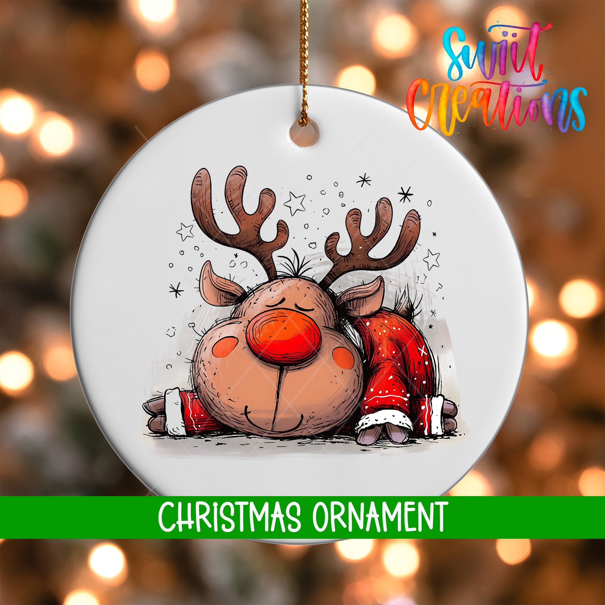 A white Christmas ornament featuring a cartoon reindeer with antlers and a red nose, surrounded by stars, against a blurred background with Christmas lights.