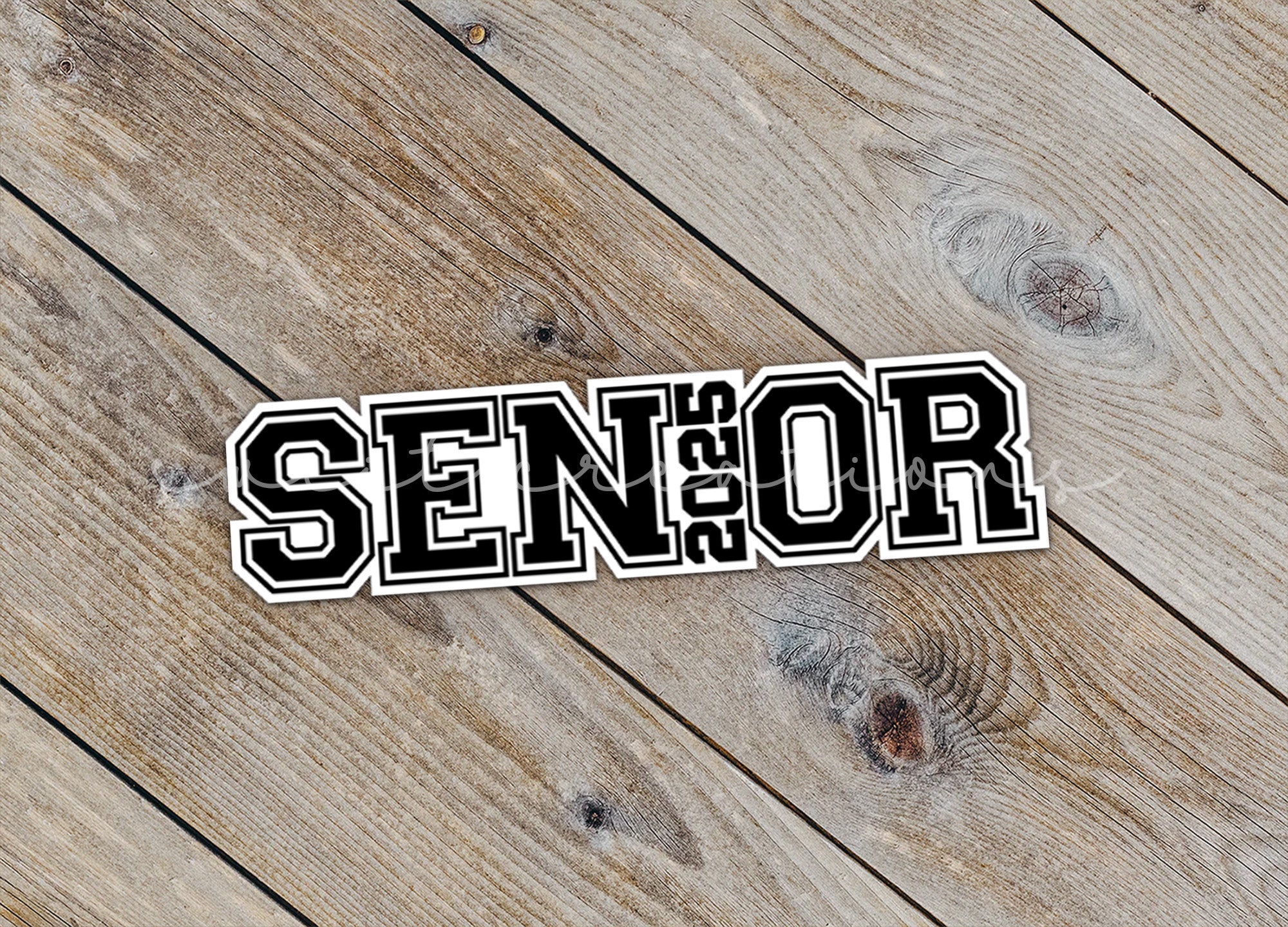 a sticker that says senior on a wooden surface