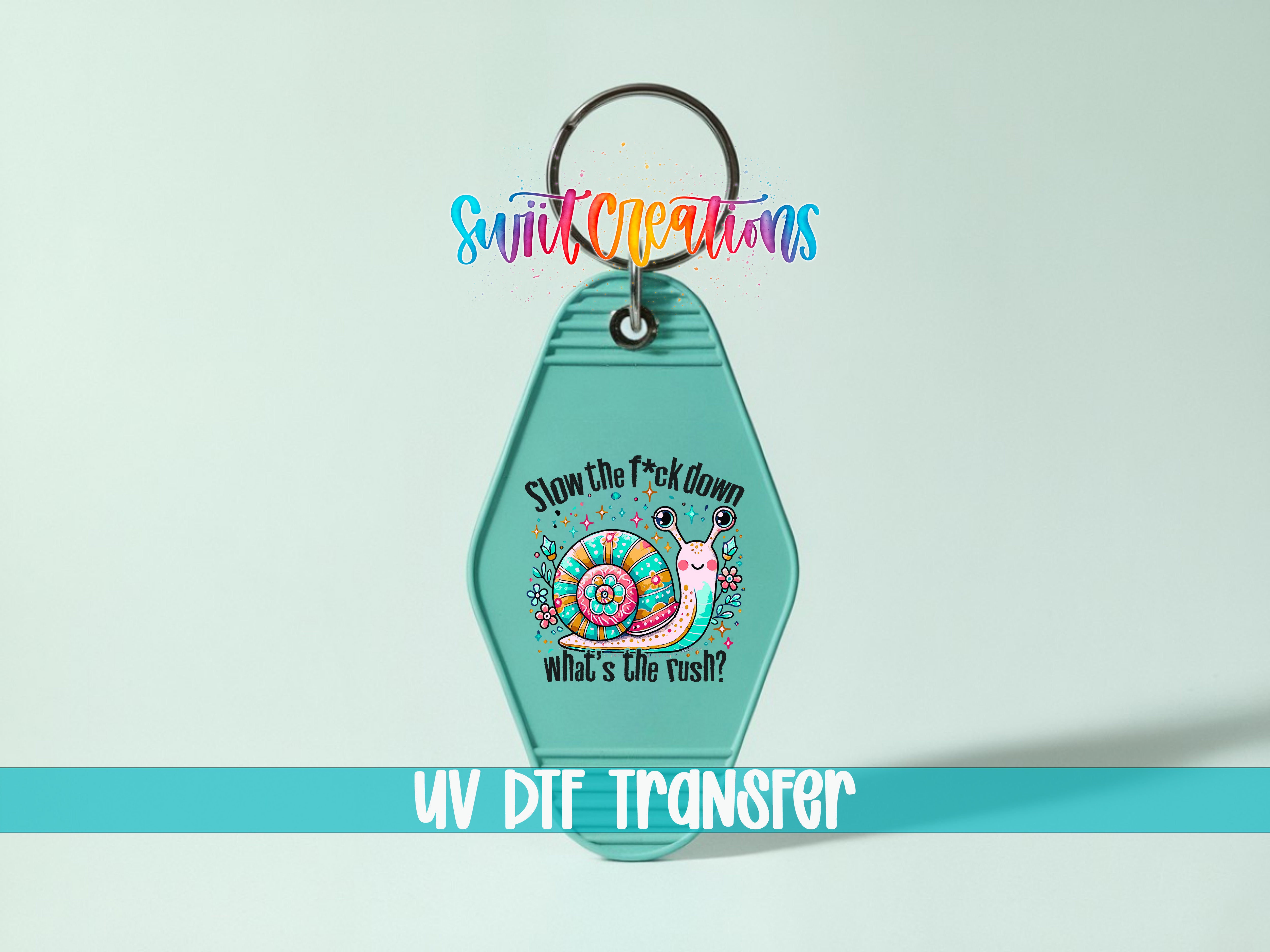 A keychain with a colorful design featuring a snail and the text "Slow the fuck down, what's the rush?"