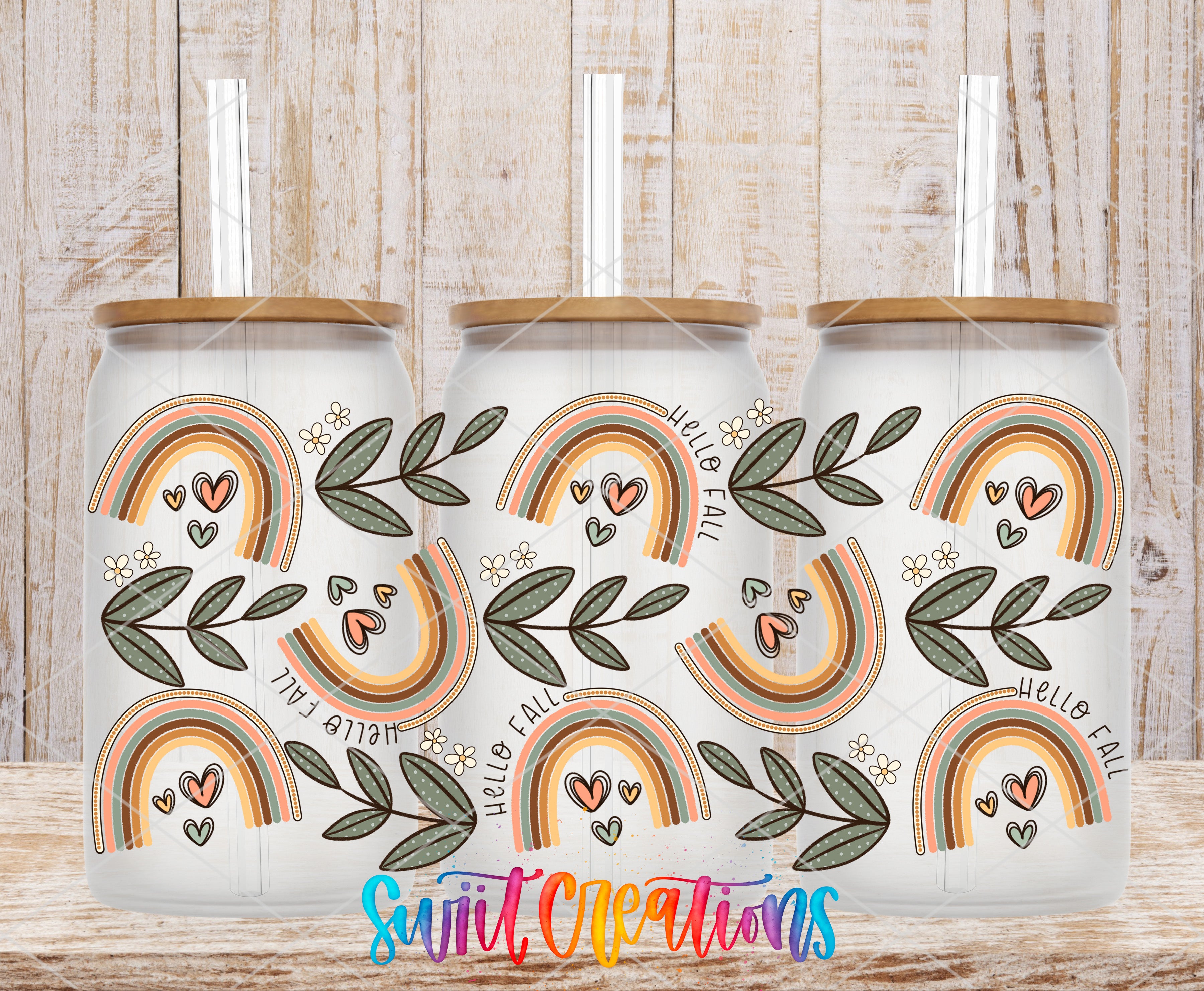three white tumblers with a colorful, rainbow-themed design on them. The tumblers have a lid and straw, and the background is a wooden wall.