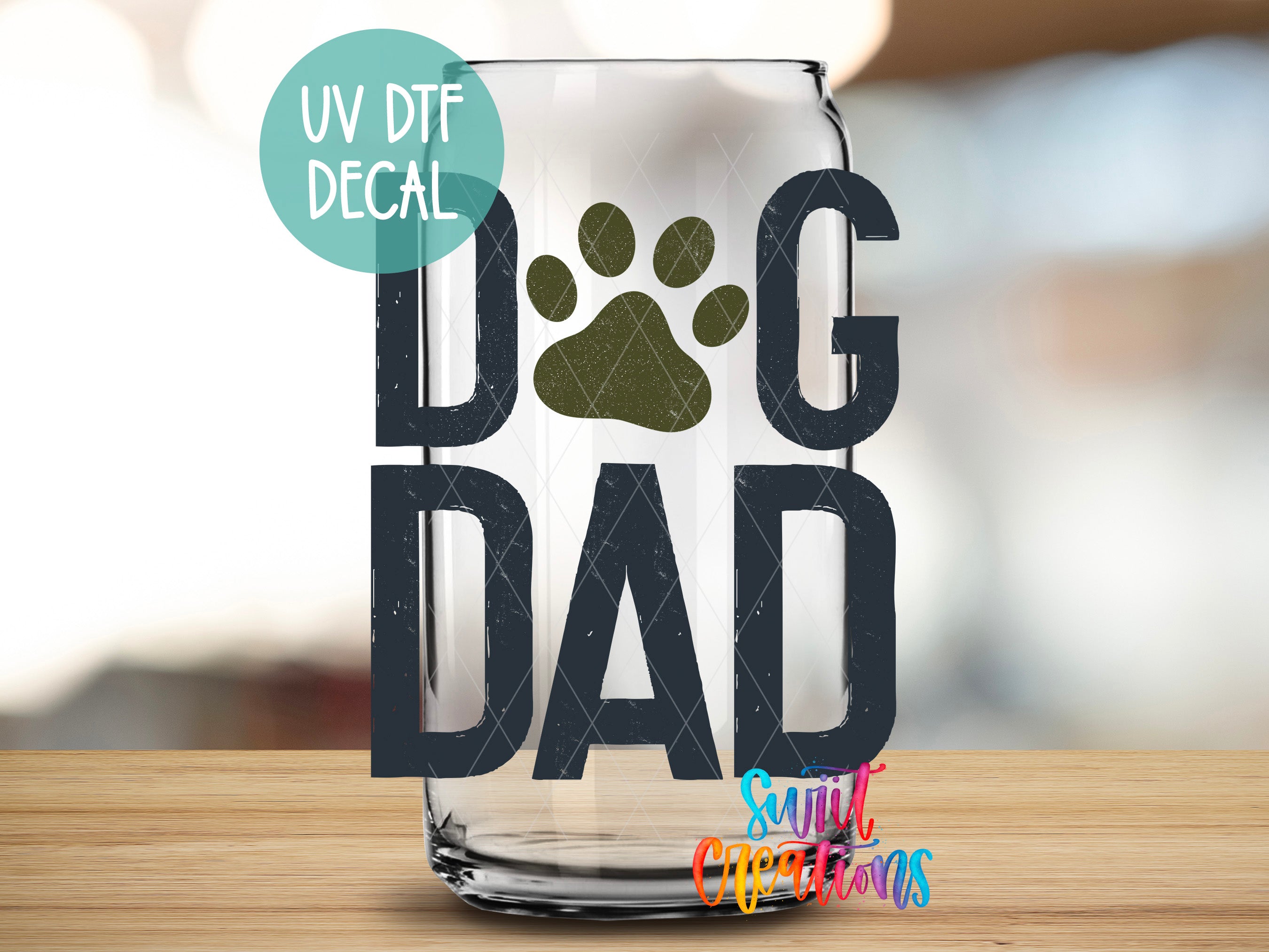 A glass with the text "DAD" and a paw print design, along with a UV decal label that says "UV DFT DECAL".