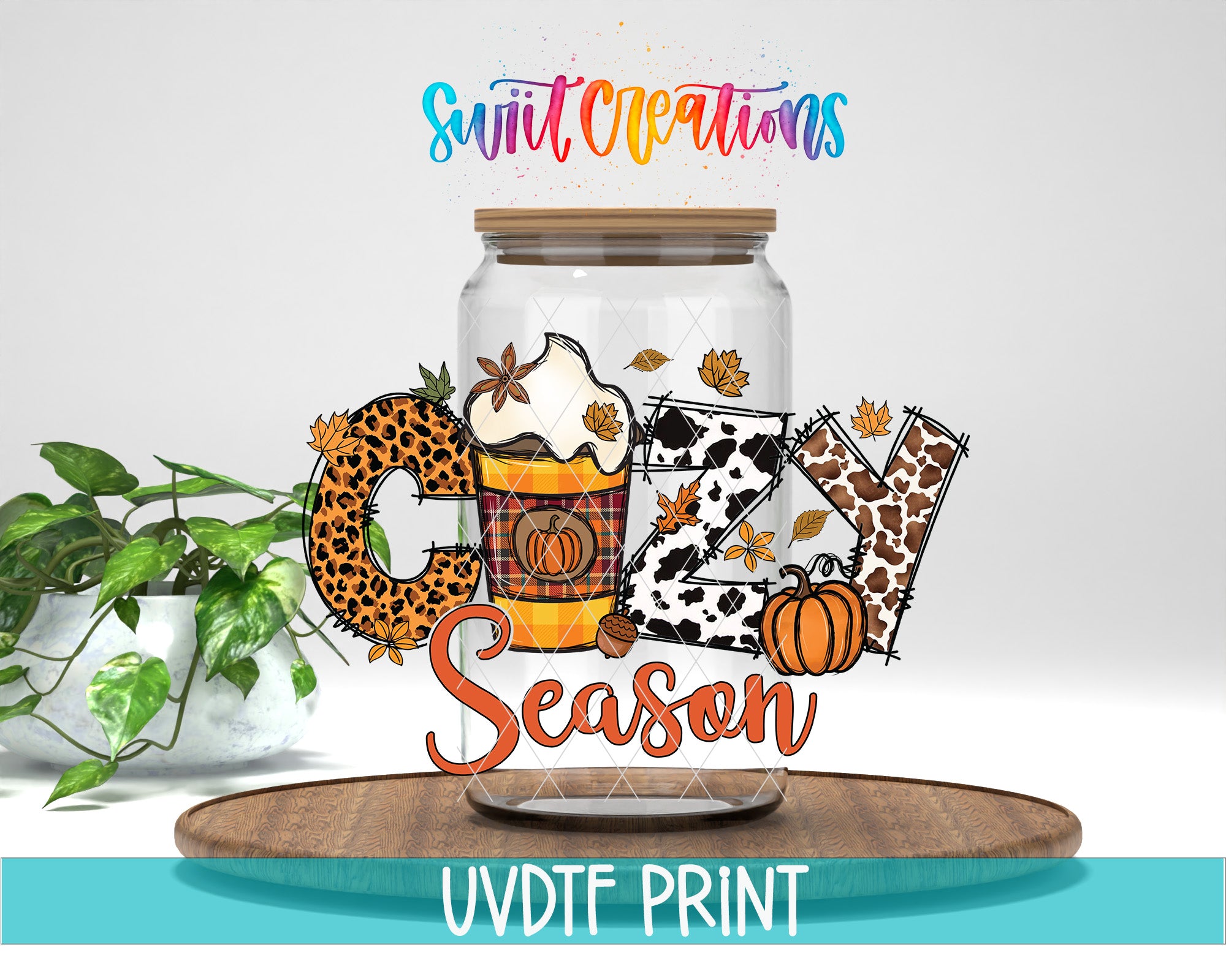 A glass jar with a lid, filled with various fall-themed items such as leaves, pumpkins, and a cup of whipped cream, along with the text "Cozy Season" and "Swift Creations" written on it. The jar is placed on a wooden surface, and there is a potted plant in the background.