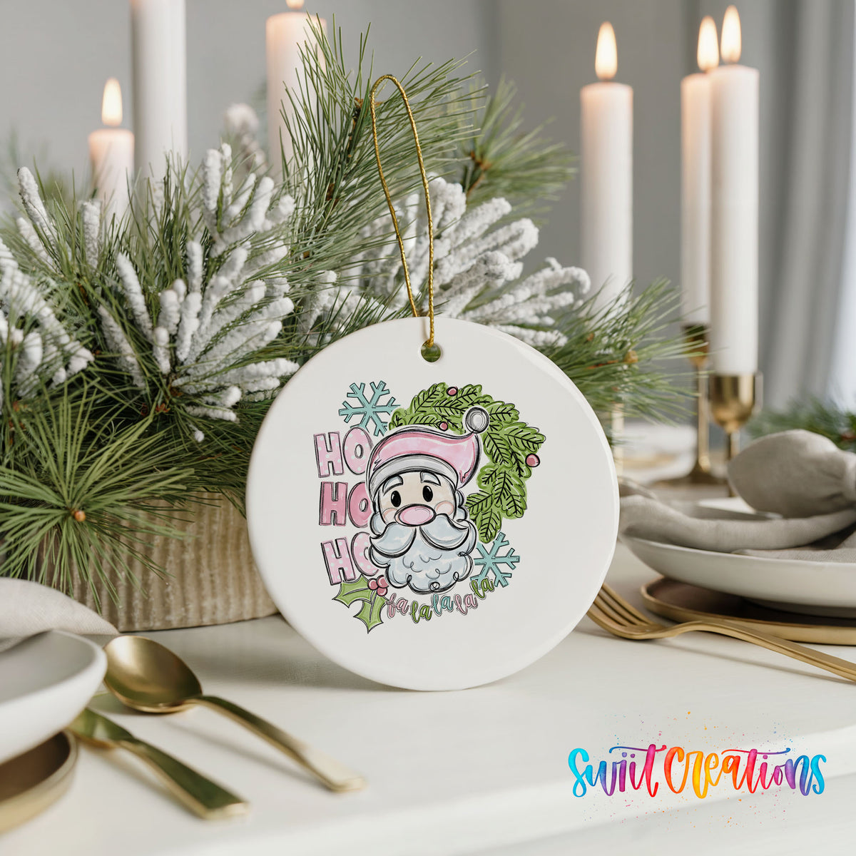 A white ceramic ornament with a Santa Claus design and the text "HOOK HOOK" is displayed on a table with candles and pine branches in the background.
