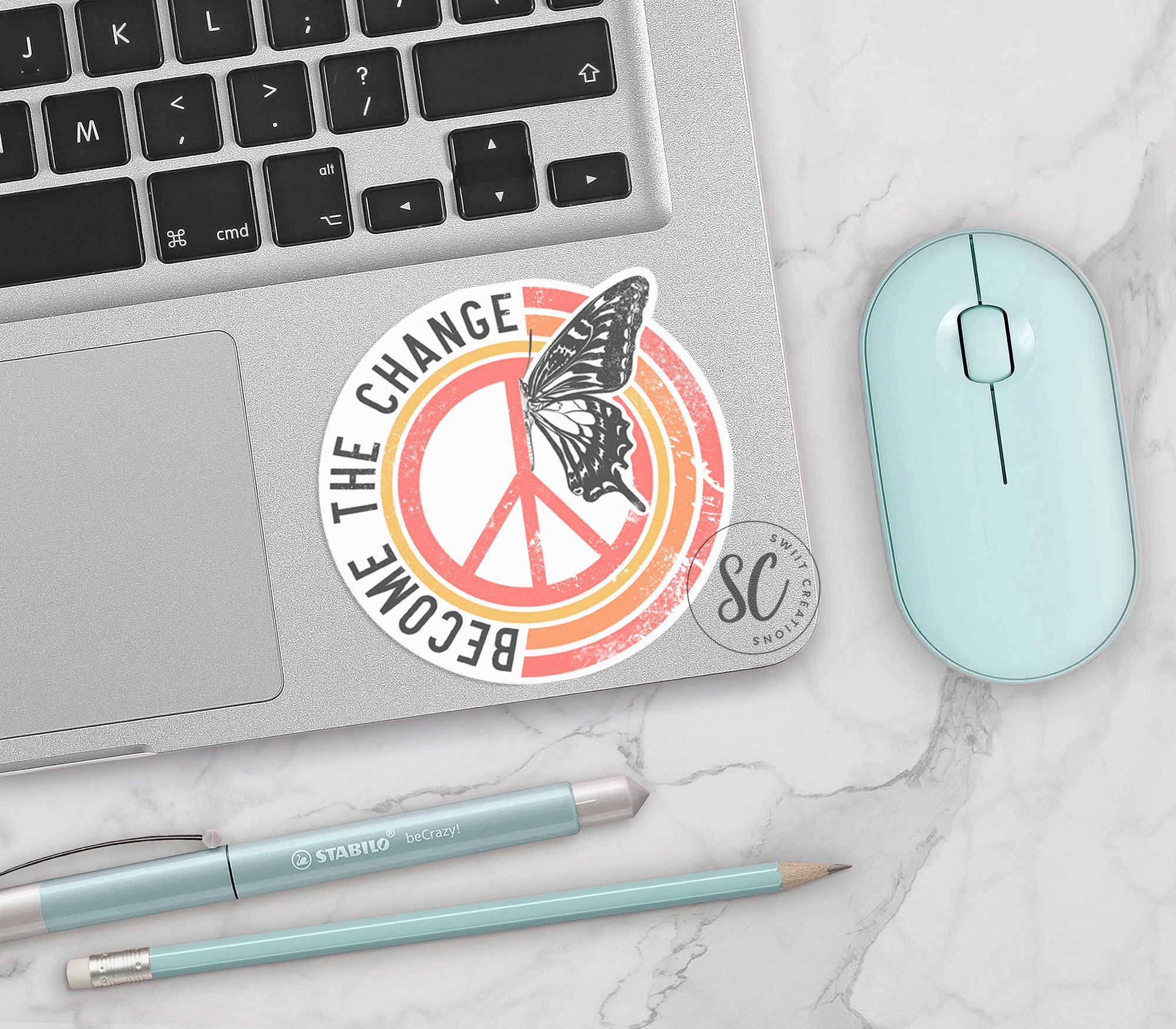 a laptop with a sticker of a peace sign and a mouse