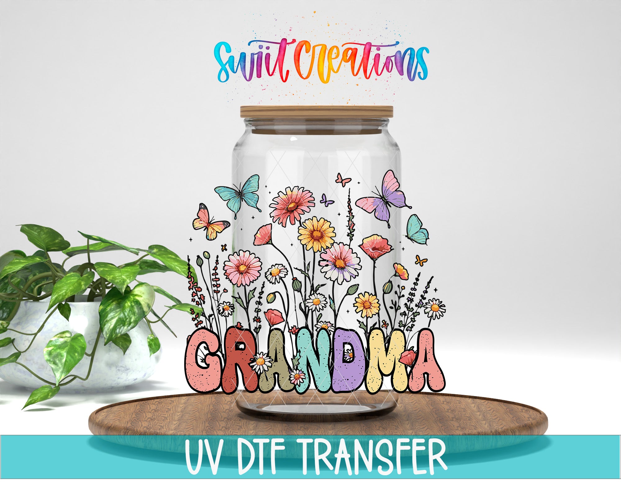 A glass jar filled with colorful flowers and butterflies, with the word "GRANDMA" written on it. The jar is placed on a wooden surface, and there is a plant in the background.