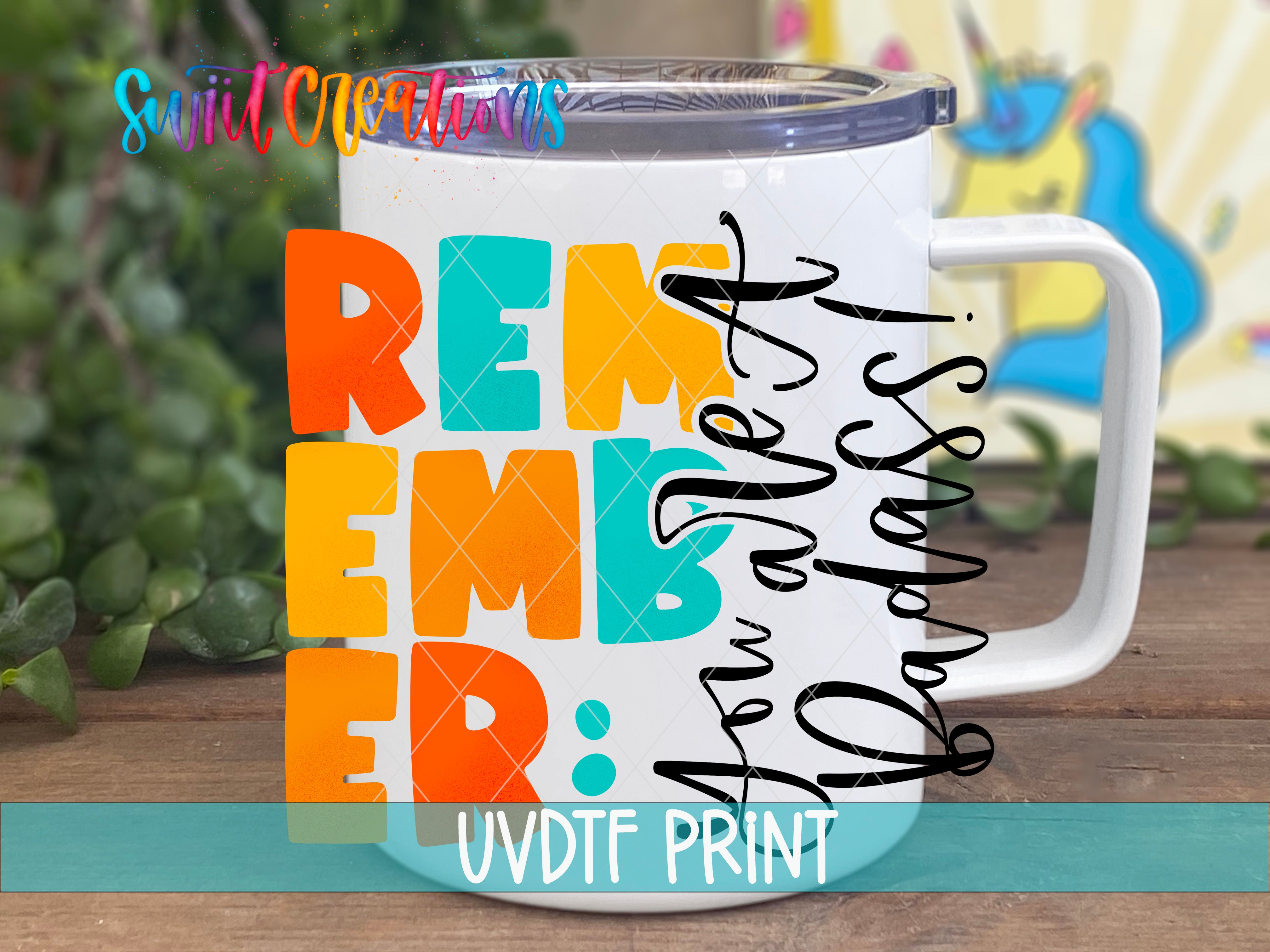 A white mug with colorful text and graphics on it, placed on a wooden surface.