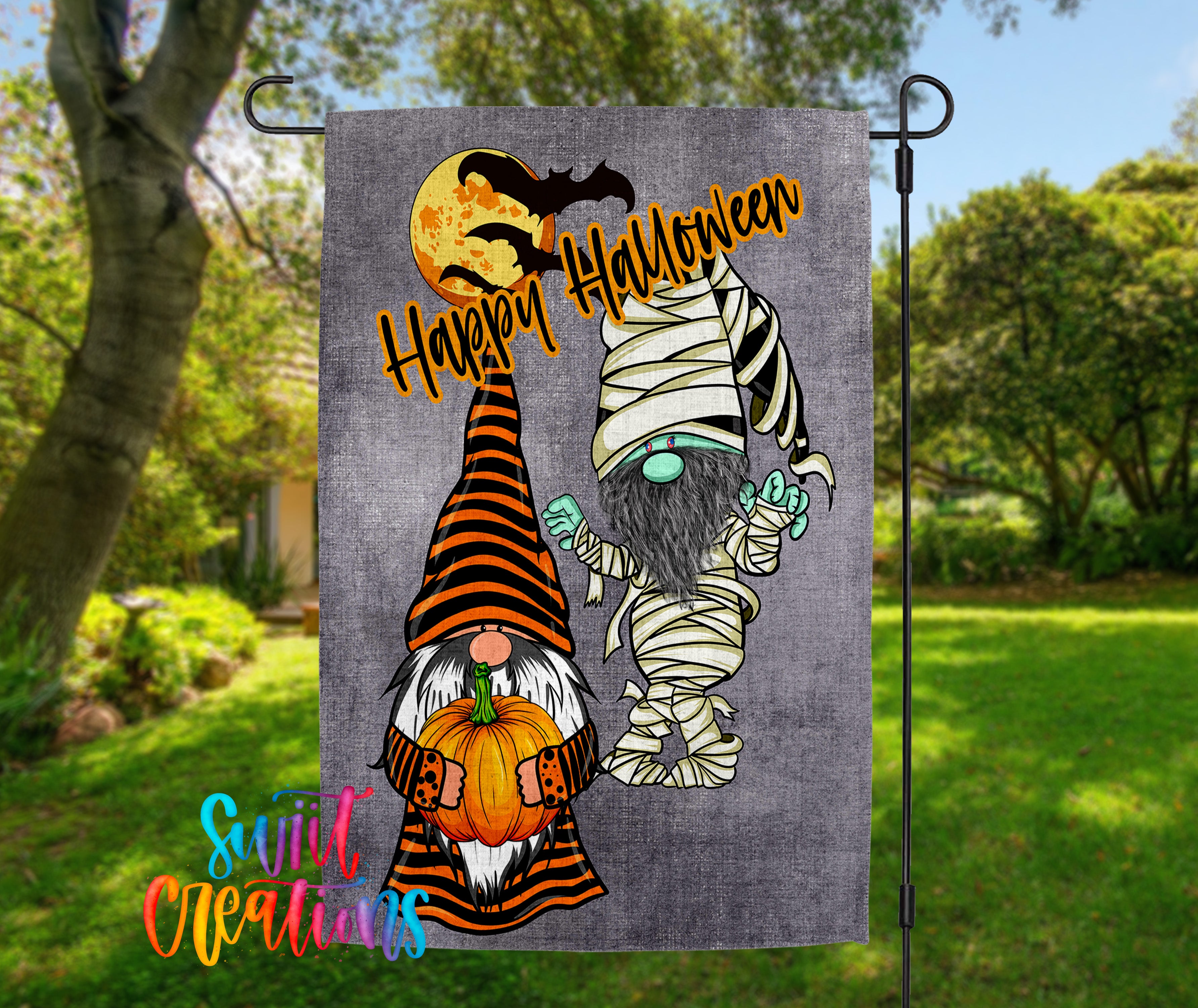 A Halloween-themed garden flag featuring two gnomes, one dressed as a mummy and the other as a gnome, holding pumpkins and a full moon.