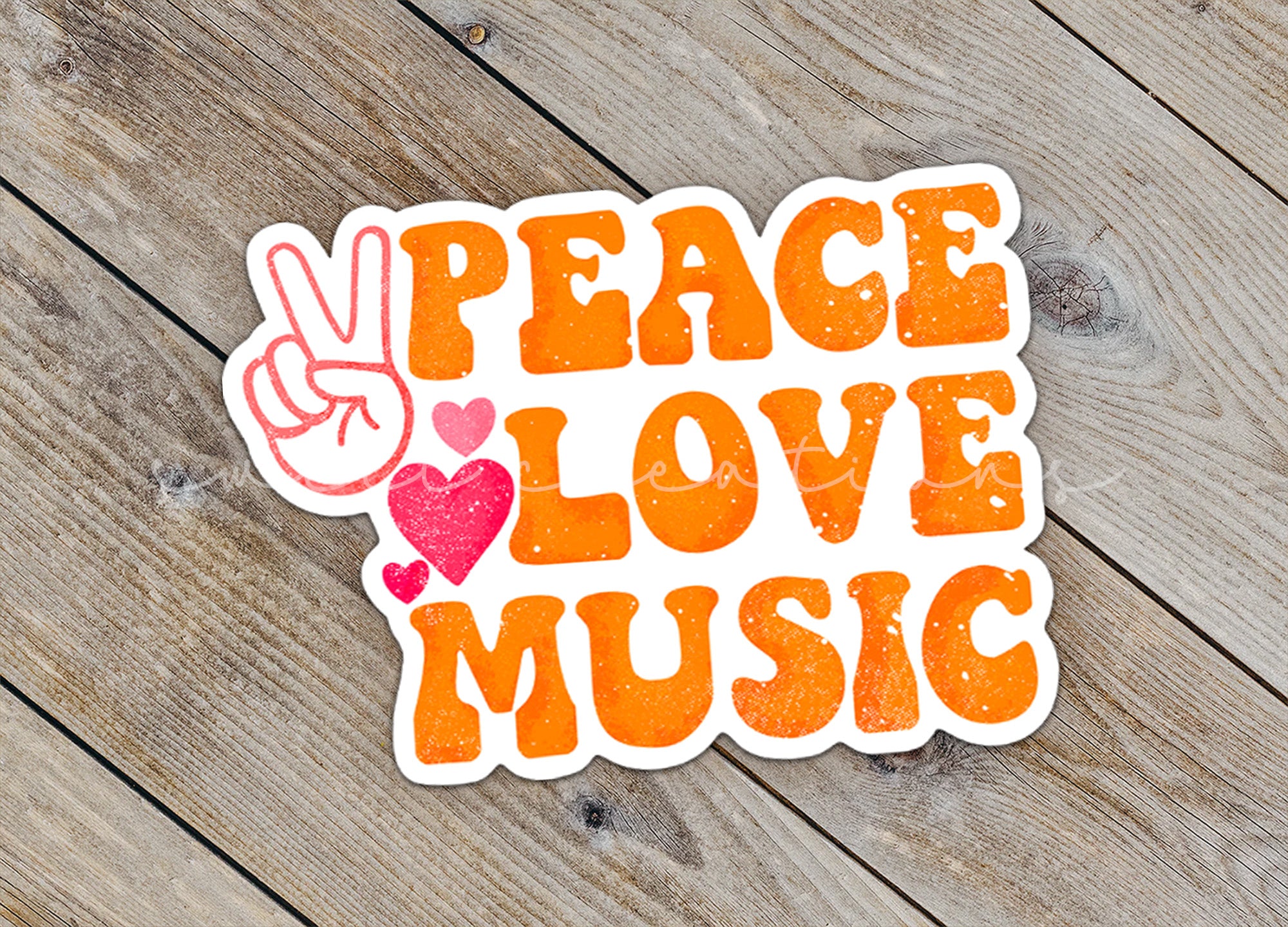 a peace love music sticker sitting on top of a wooden table