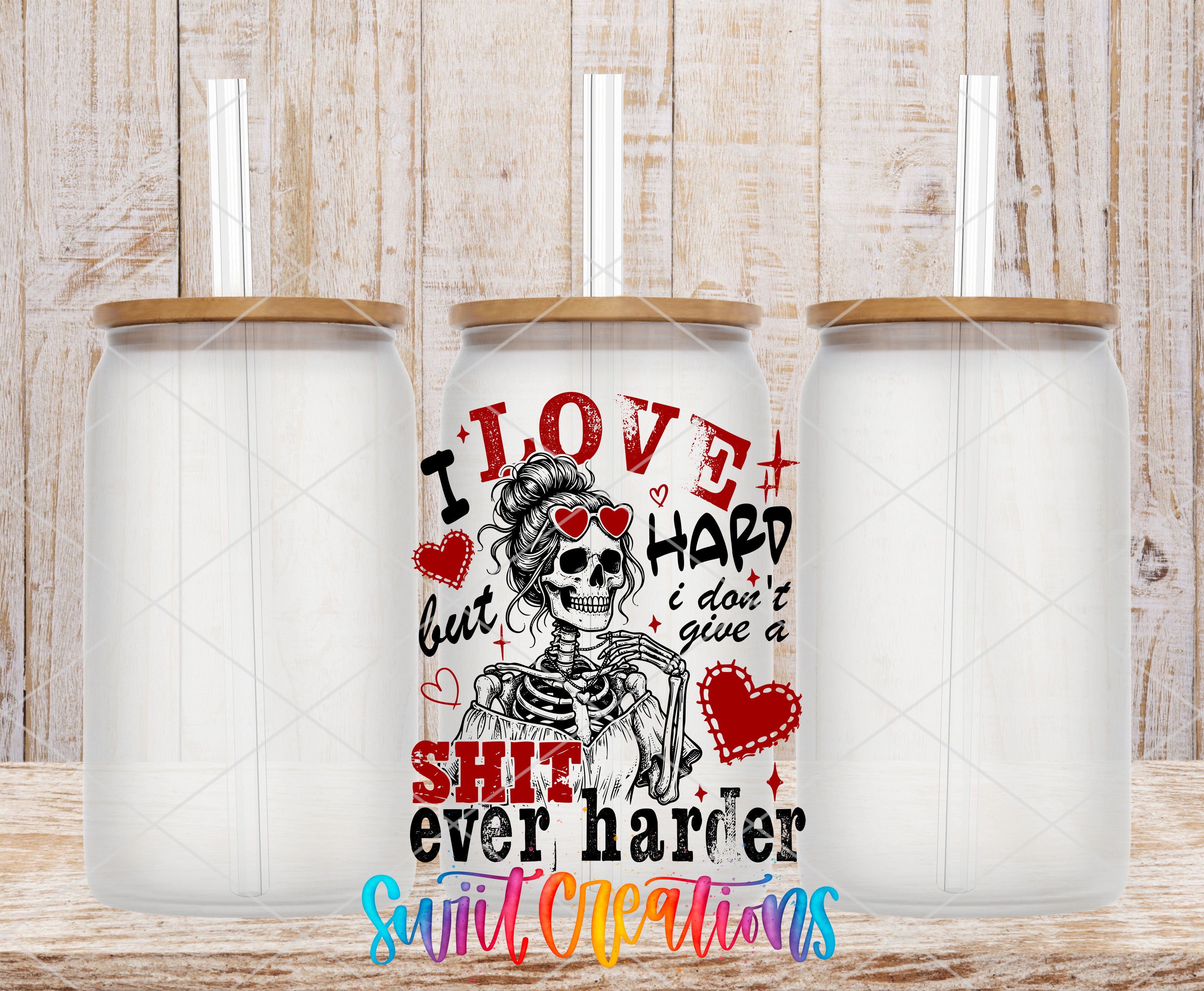 three clear glass jars with lids, each containing a straw. The jars are arranged in a row, and there is a colorful design on the front of one of the jars that includes a skeleton wearing sunglasses and the text "I LOVE HARD but I DON'T GIVE A SHIT ever harder".
