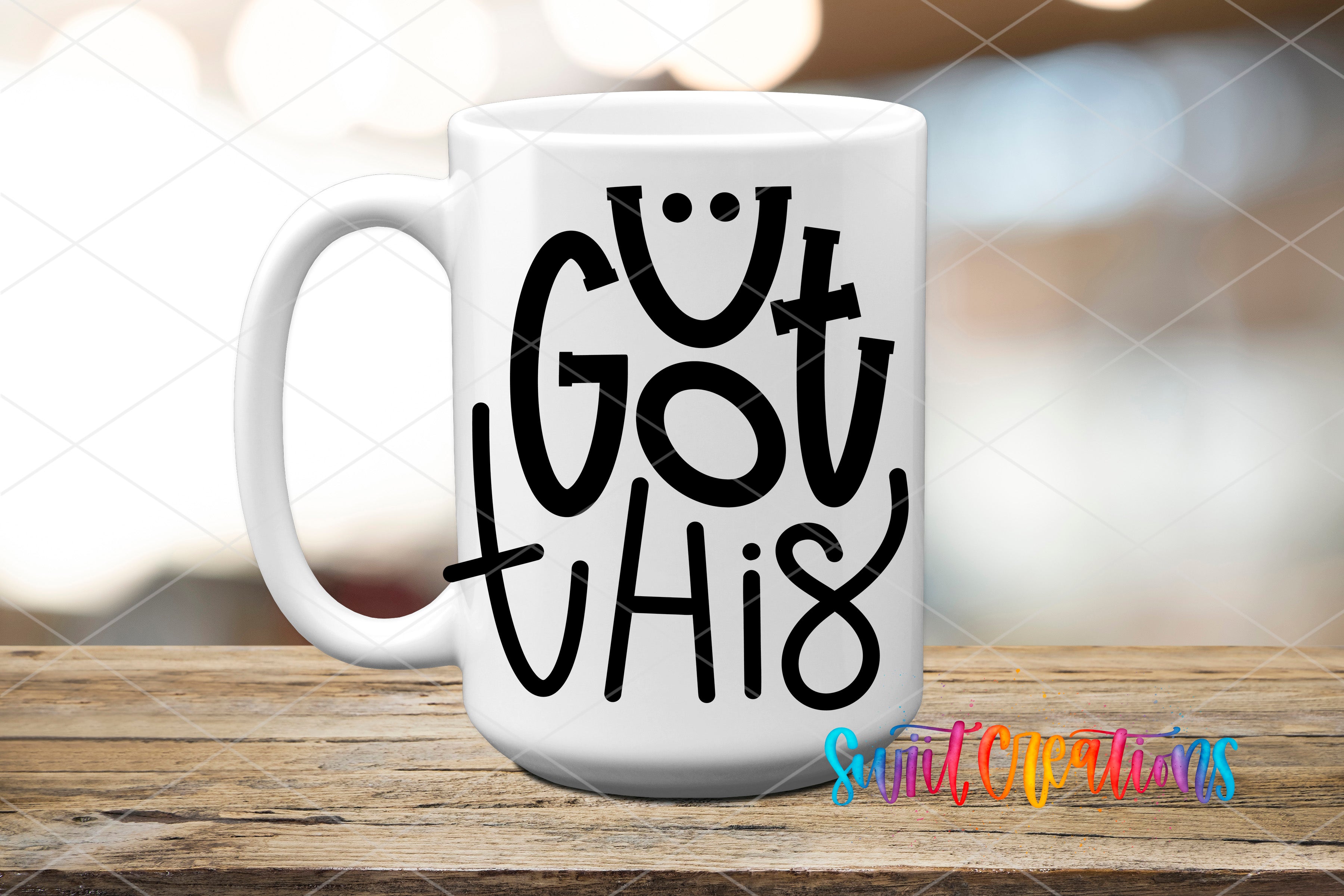 A white mug with the text "Cut This" printed on it, sitting on a wooden surface.