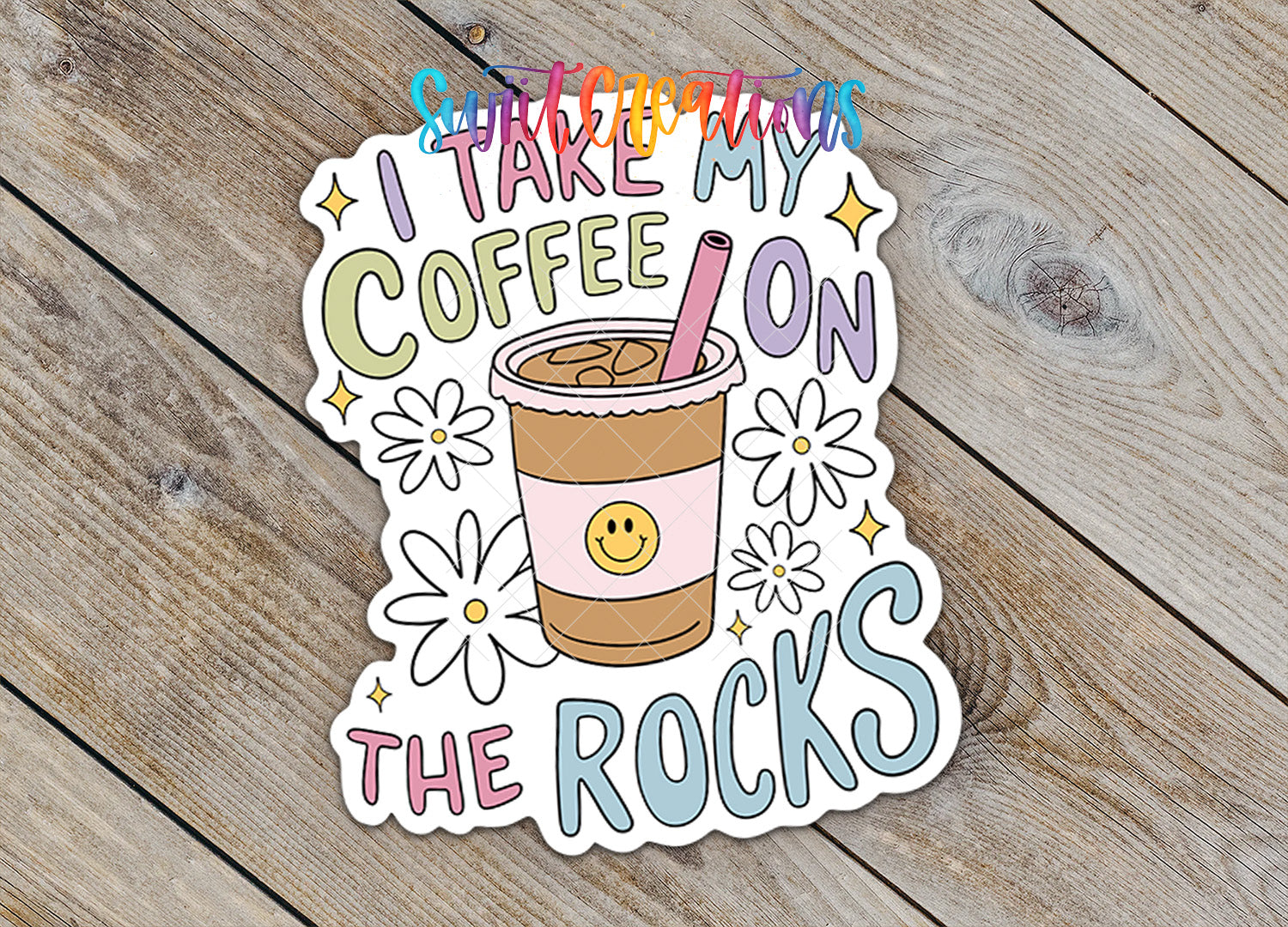 A sticker with a coffee cup and flowers, along with the text "I TAKE MY COFFEE ON THE ROCKS" written on it.