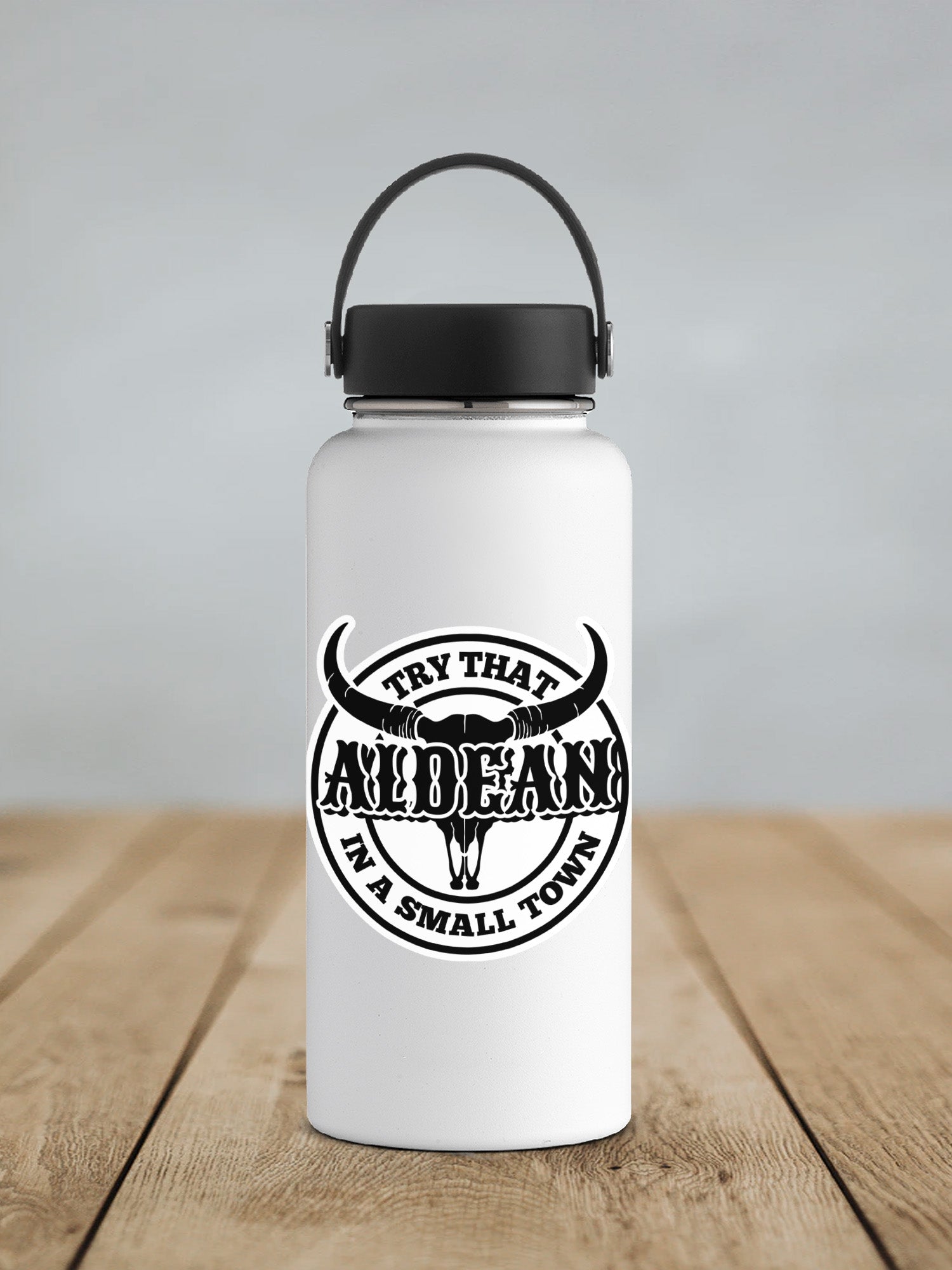 a white water bottle with a black lid on a wooden table