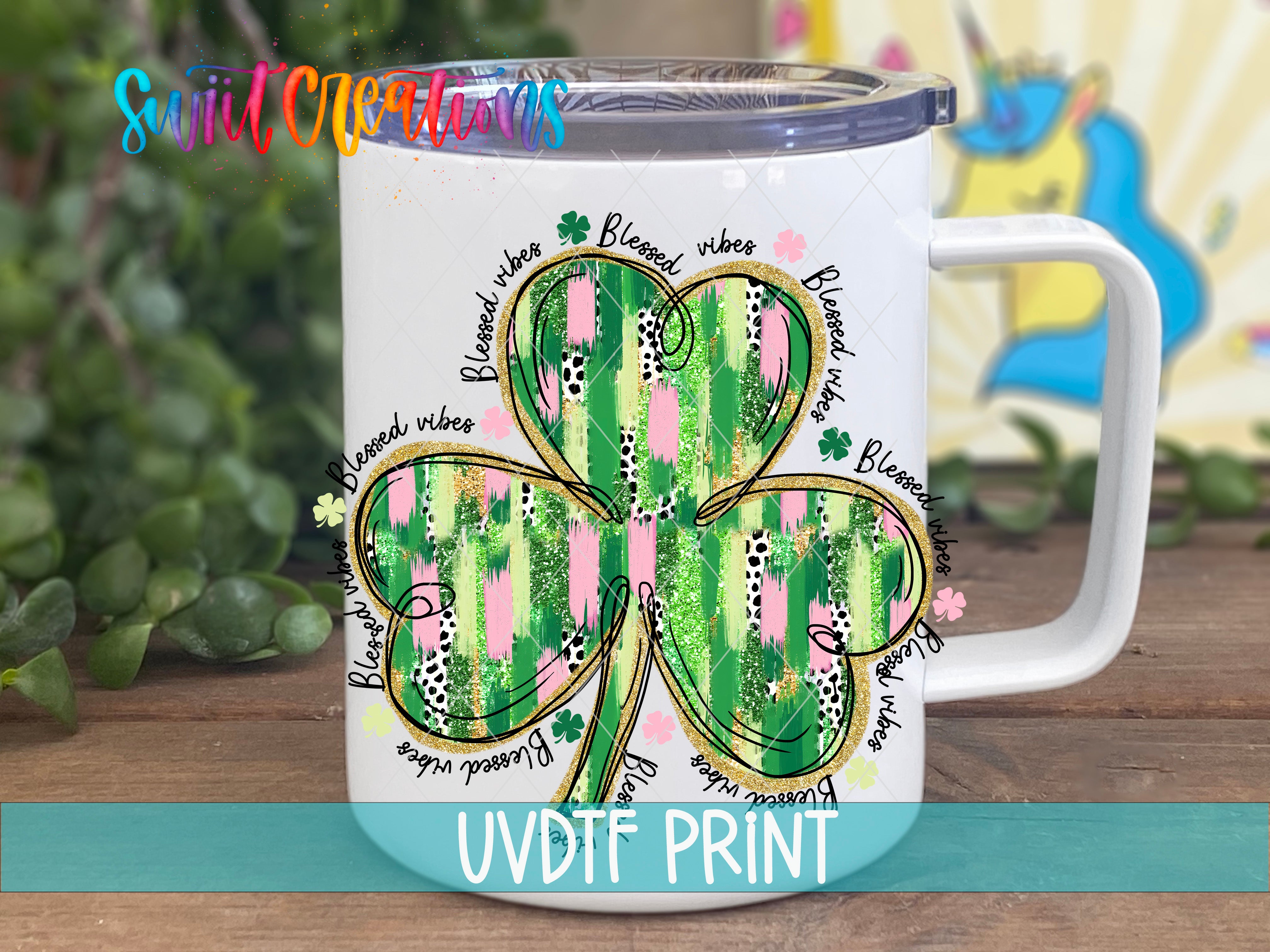 a white coffee mug with a four leaf clover on it