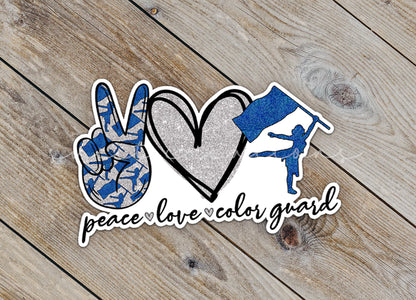 a peace love color guard sticker on a wooden surface