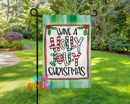A garden flag with a festive holiday message, "Have a Holly Jolly Christmas", is displayed in a lush, green outdoor setting.
