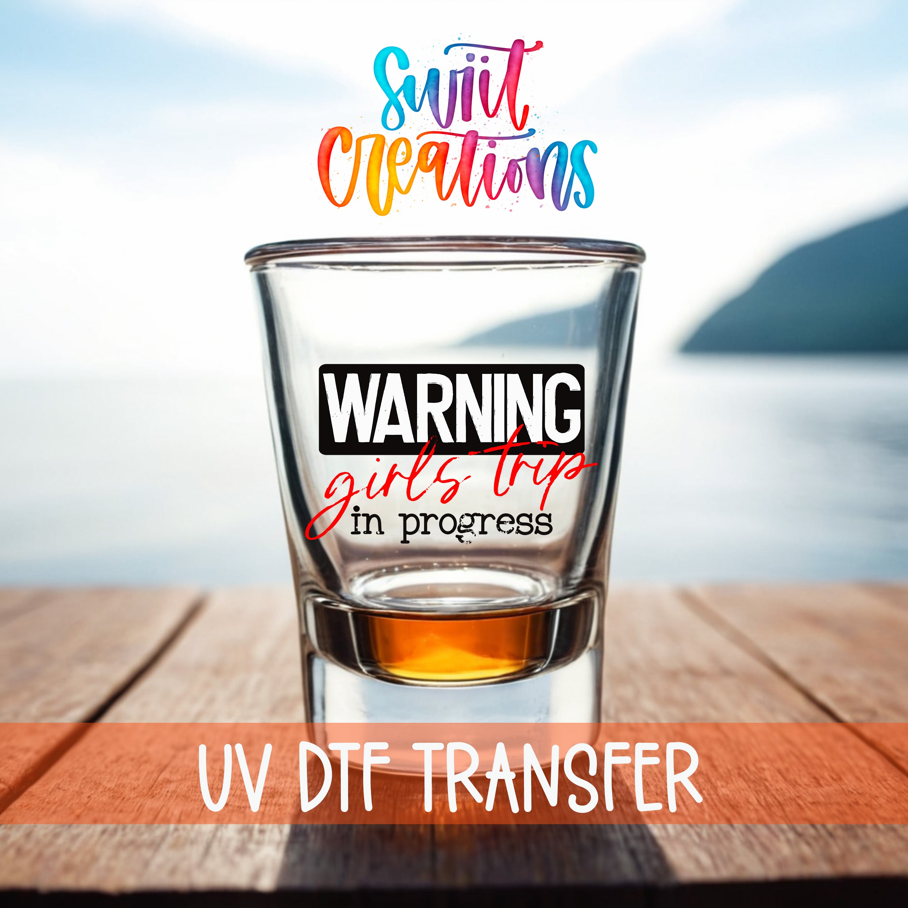 a shot glass with a warning label on it, placed on a wooden surface with a body of water in the background.