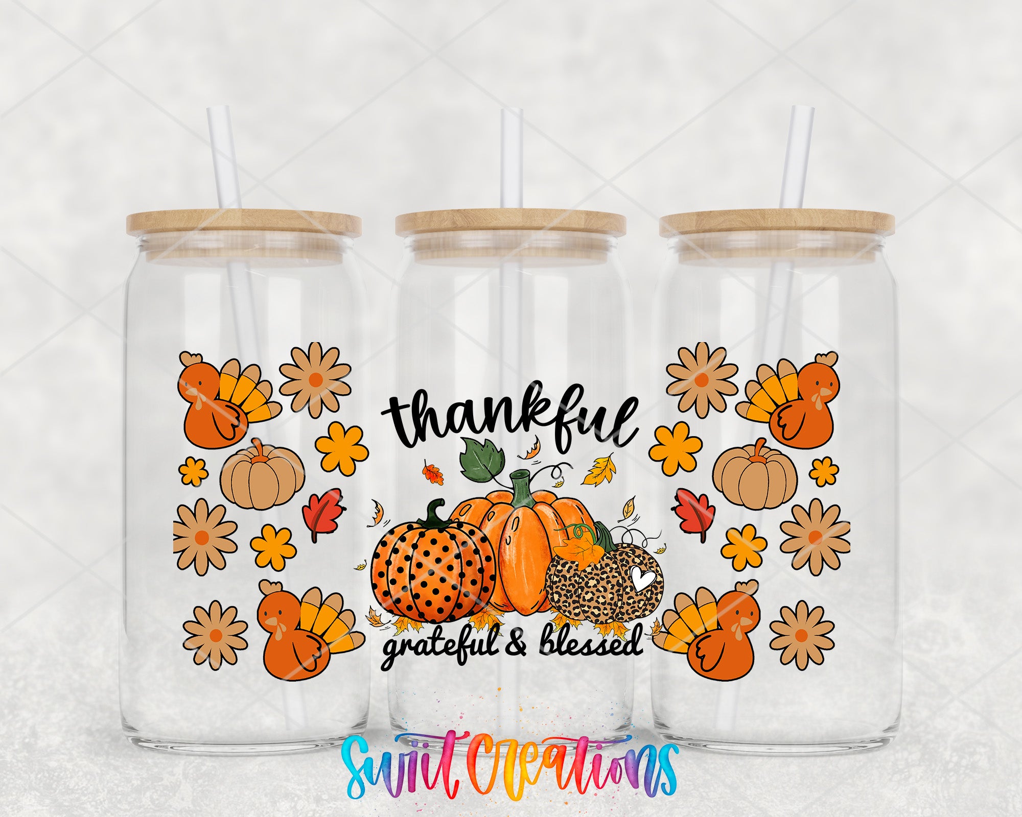 three glass tumblers with a Thanksgiving theme, including pumpkins, turkeys, and flowers. The tumblers have straws on the lids and the text "Thankful" and "grateful & blessed" printed on them.