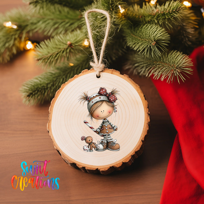 A wooden ornament featuring a smiling girl with a gingerbread man, hanging on a Christmas tree.