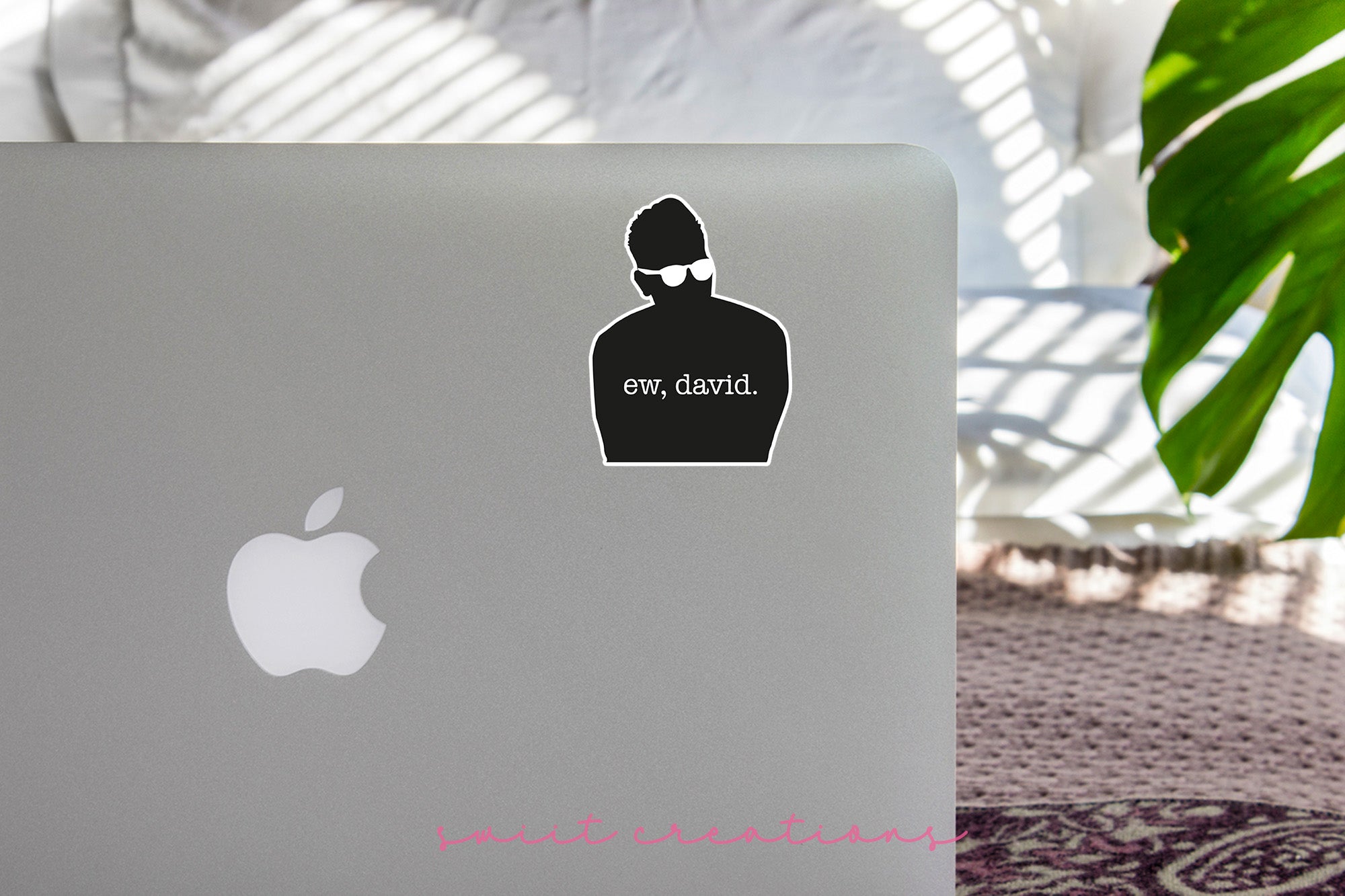 a laptop with a sticker of a man in a hat and sunglasses