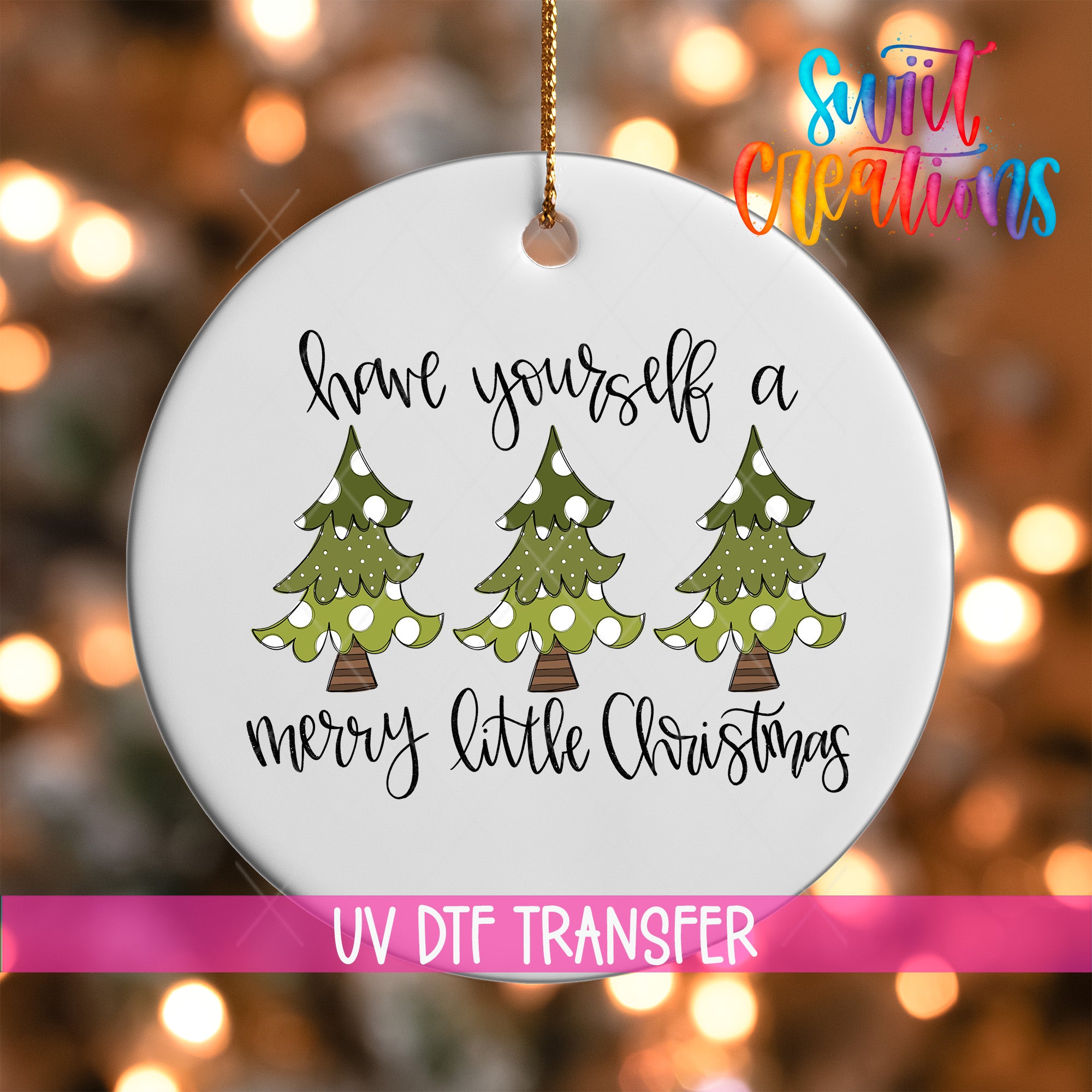 A white ornament with a Christmas tree design and the text "Have yourself a merry little Christmas" hanging from a string.