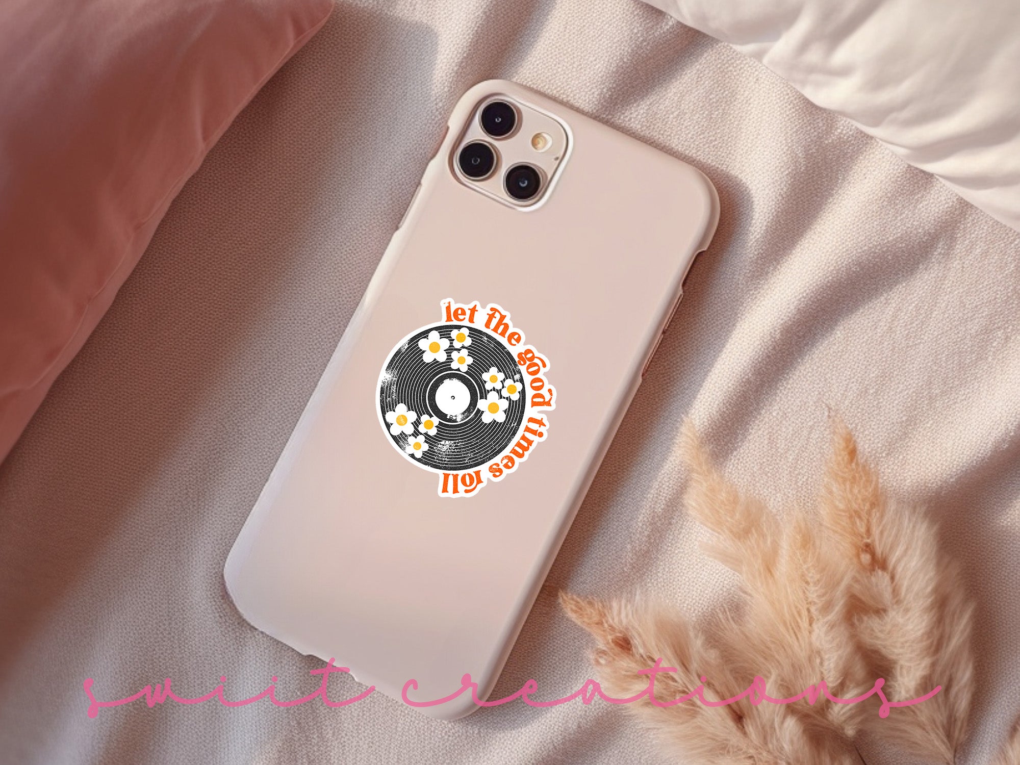 a phone case with a sticker on it sitting on a bed