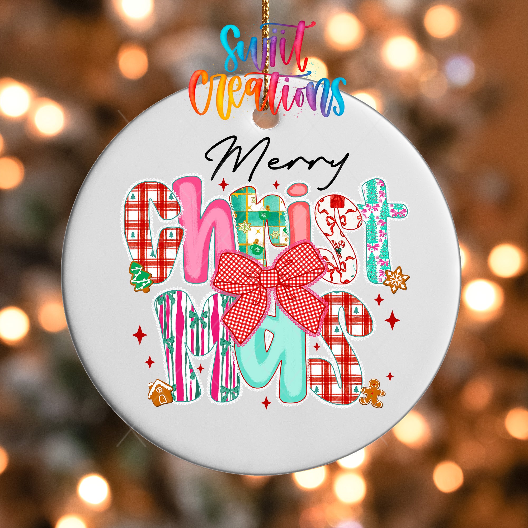 A white ornament with colorful text and decorative elements, including a bow, is hanging against a blurred background with Christmas lights.