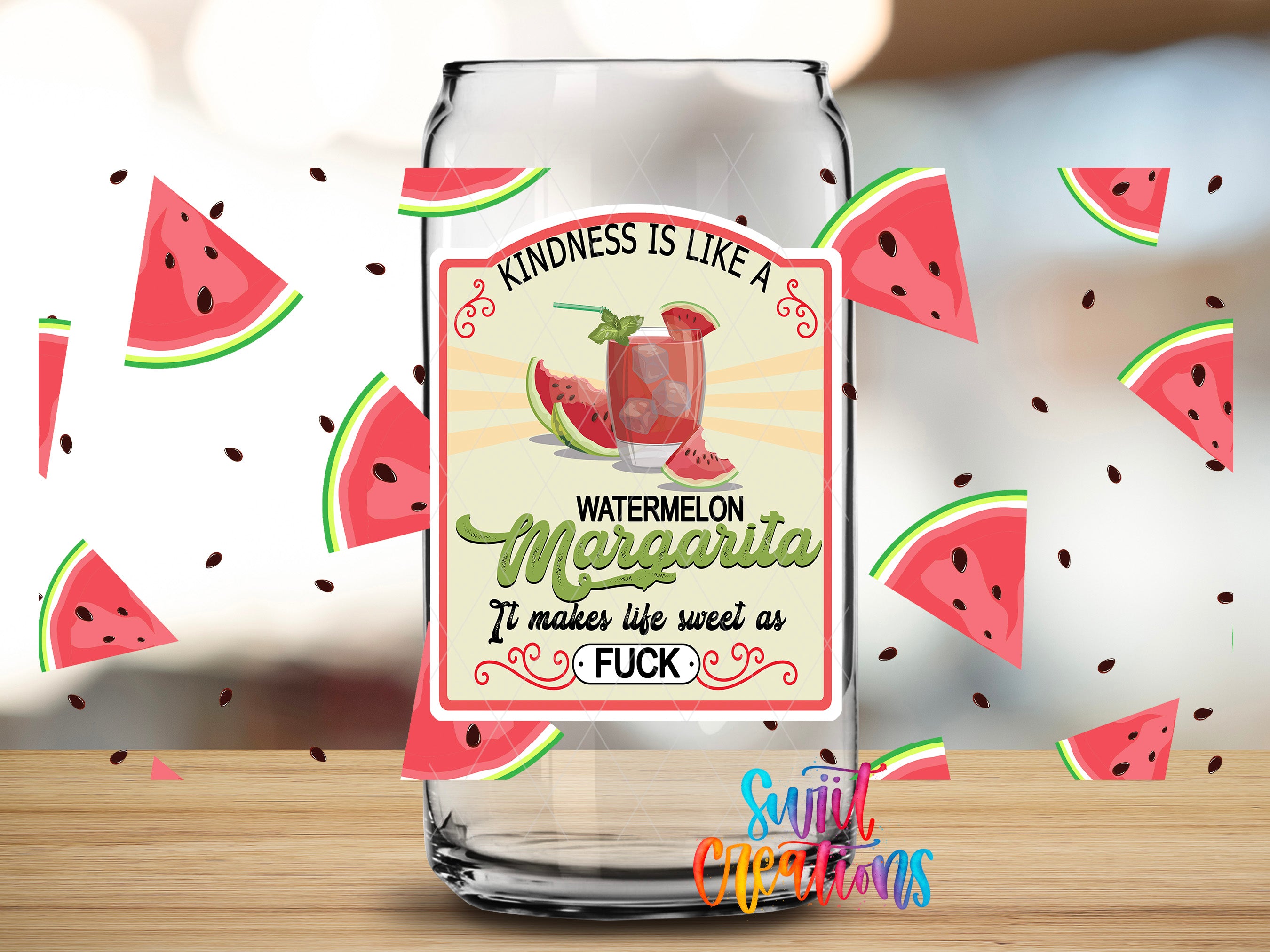 a clear glass bottle with a label that says "Kindness is like a WATERMELON MARGARITA. It makes life sweet as F*CK". The bottle is surrounded by watermelon slices, and there are additional watermelon slices scattered around the bottle.