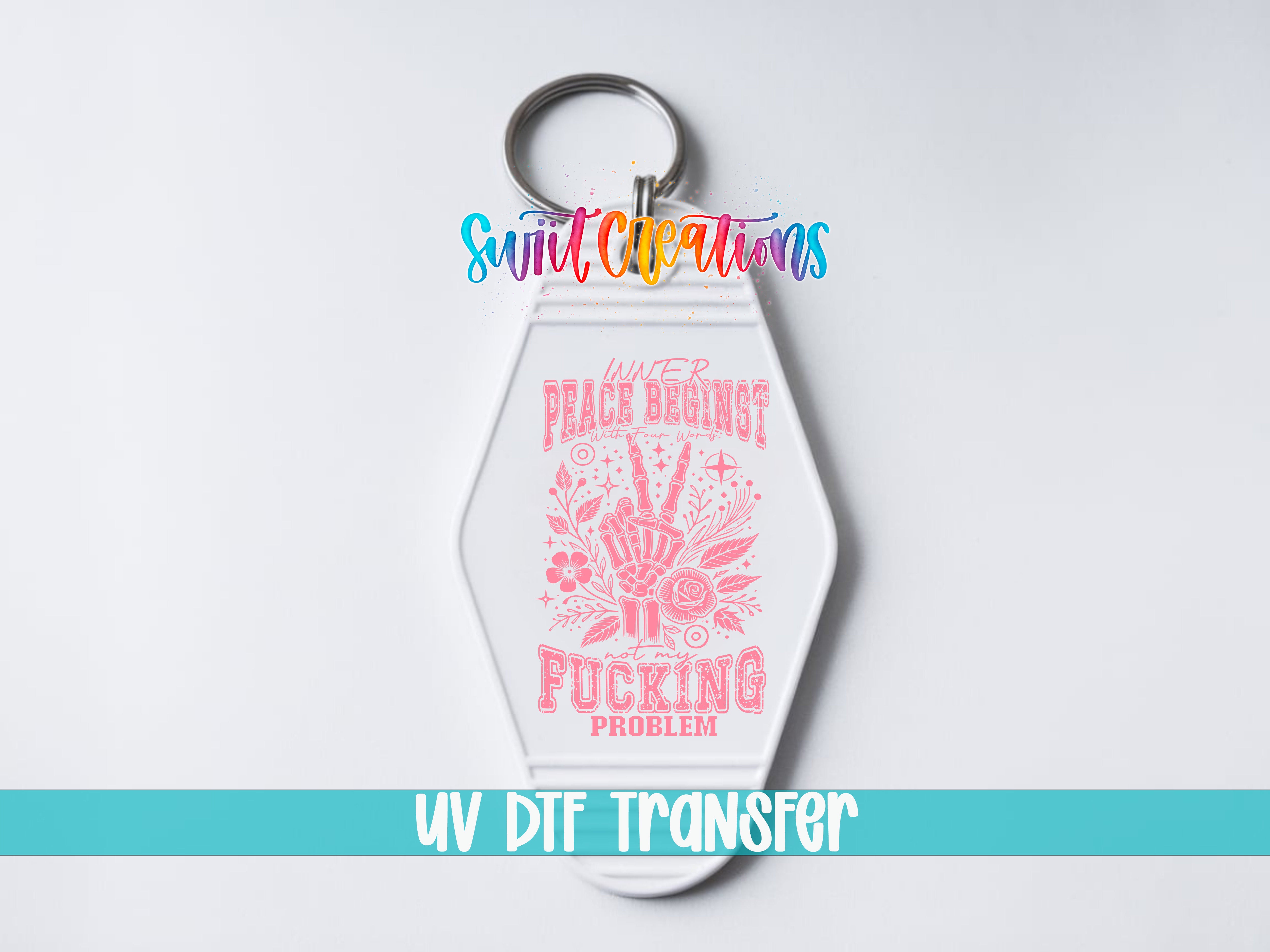 A keychain with a pink and white design featuring a hand gesture and text that reads "Peace begins with a gun".