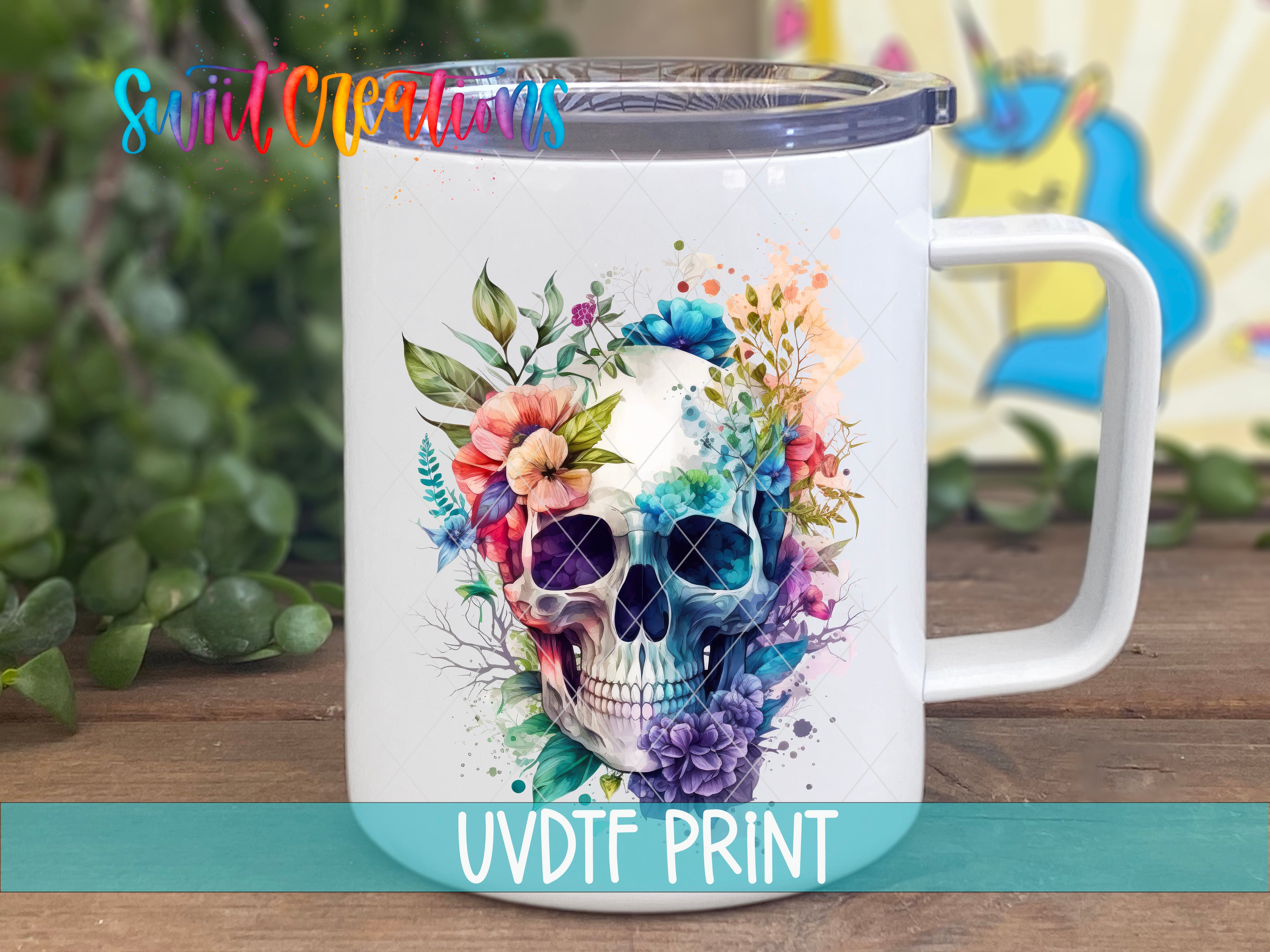 A white ceramic mug with a colorful floral design featuring a skull surrounded by flowers and leaves.