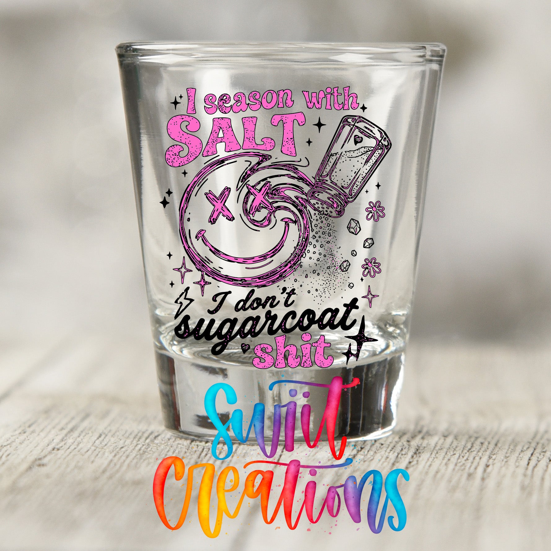 A shot glass with a humorous text and graphic design printed on it.