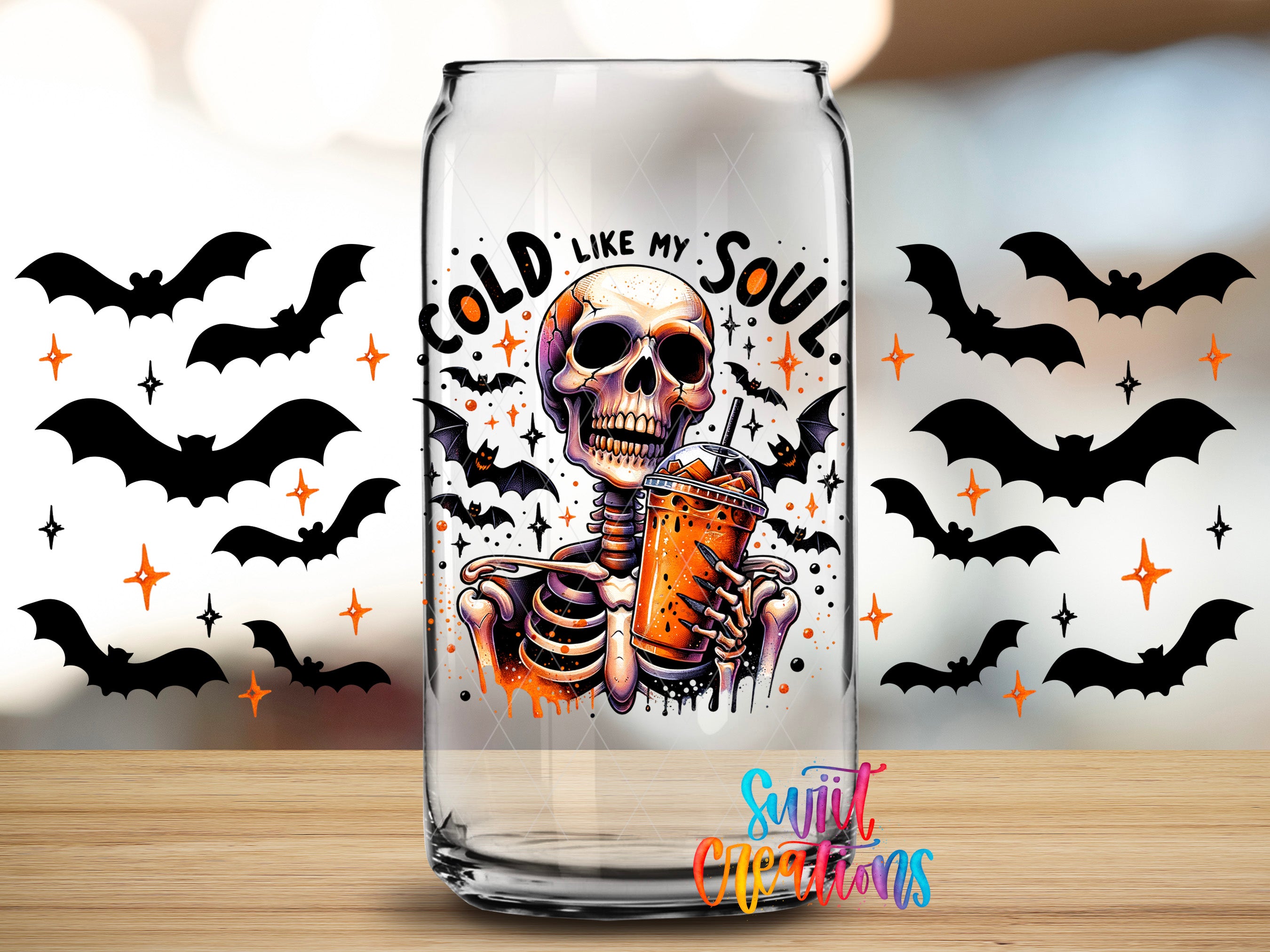 A glass can with a skeleton holding a drink, surrounded by bats and stars, with the text "COLD LIKE MY SOUL" and "Sunlit Creations" written on it.