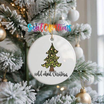 A white Christmas tree decorated with ornaments, including a leopard print ornament, and a sign that says "wild about Christmas".