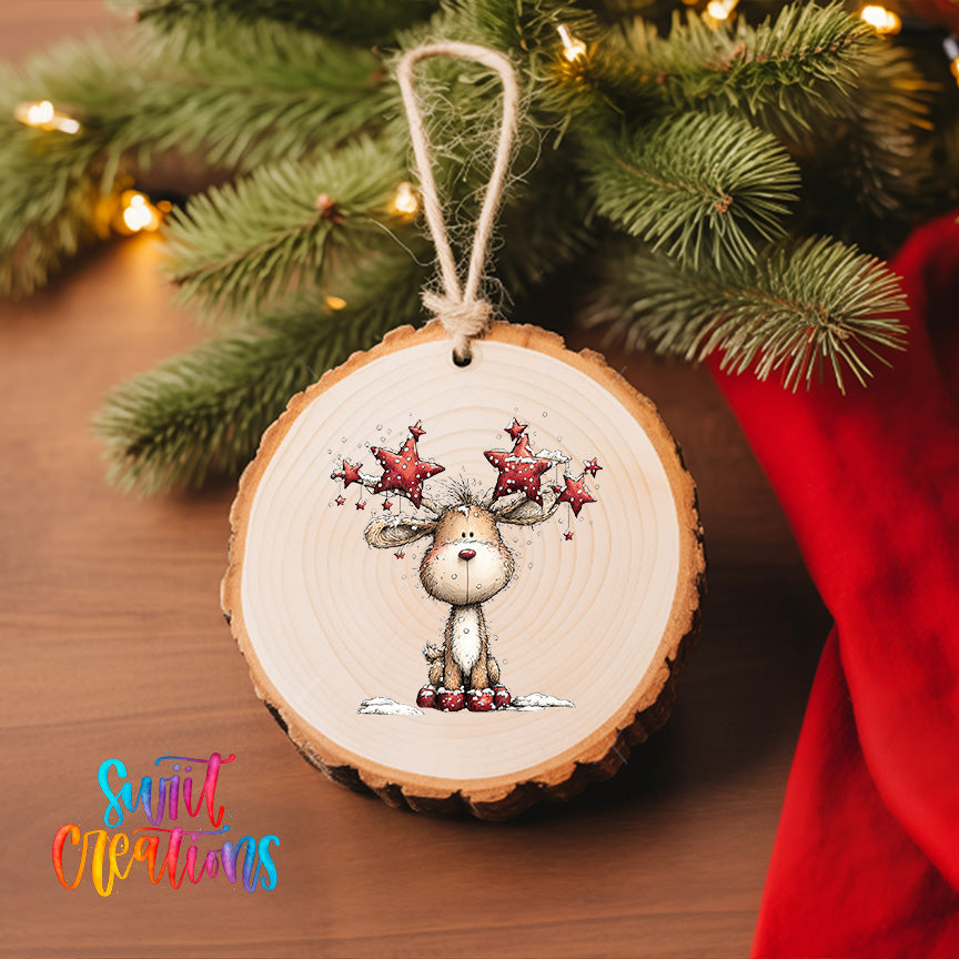 A wooden ornament with a deer-like figure and star-filled antlers is hanging on a Christmas tree, surrounded by pine branches and twinkling lights.