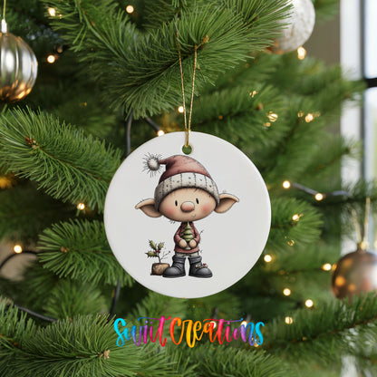 A white ceramic ornament featuring a cartoon elf wearing a hat and holding a small plant, hanging on a Christmas tree.