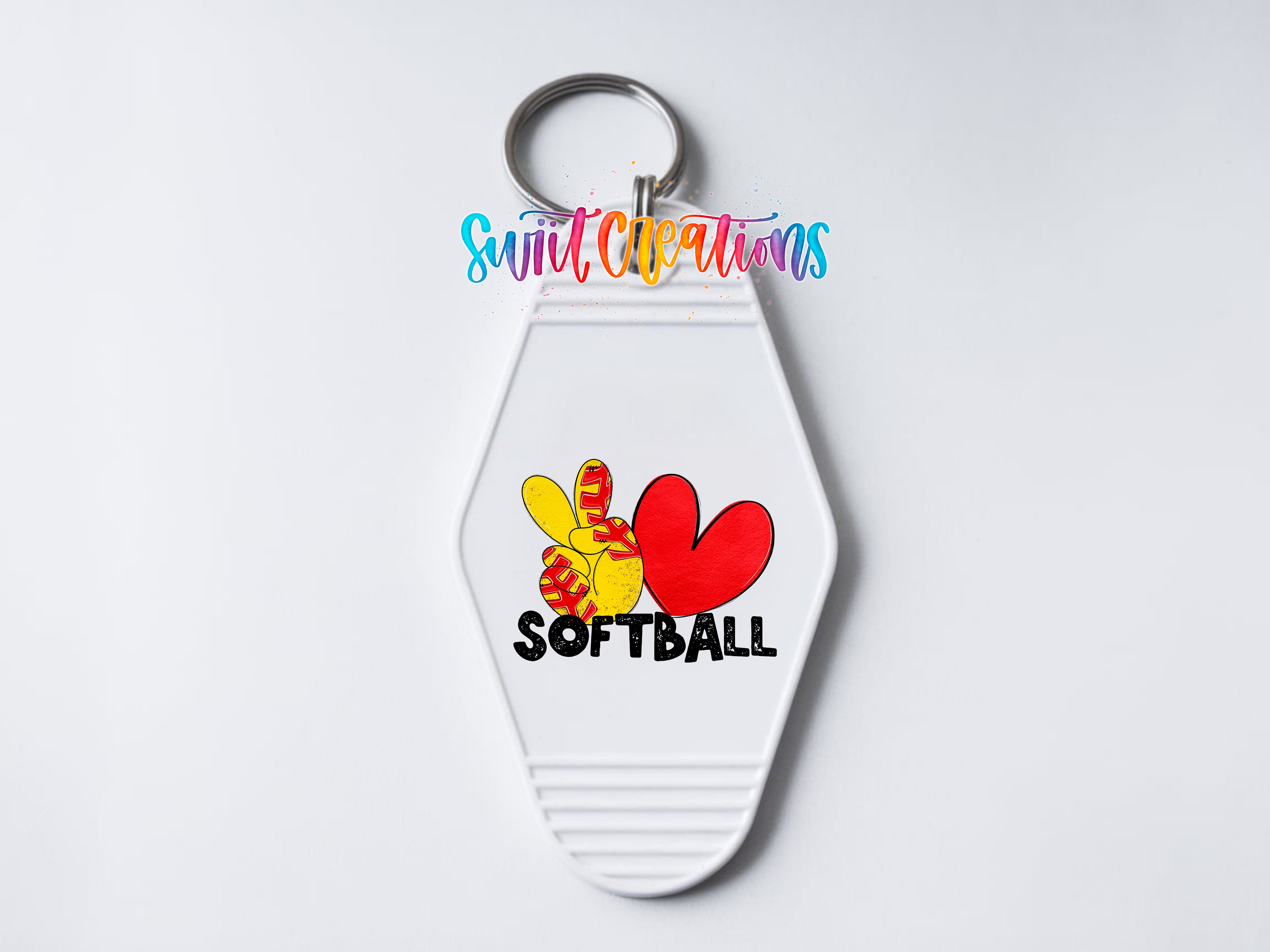 A keychain with a peace sign and the word "SOFTBALL" printed on it.