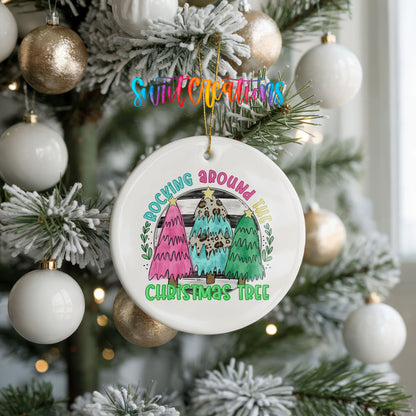 A Christmas tree decorated with ornaments, including a white ornament with a colorful design hanging from the tree.