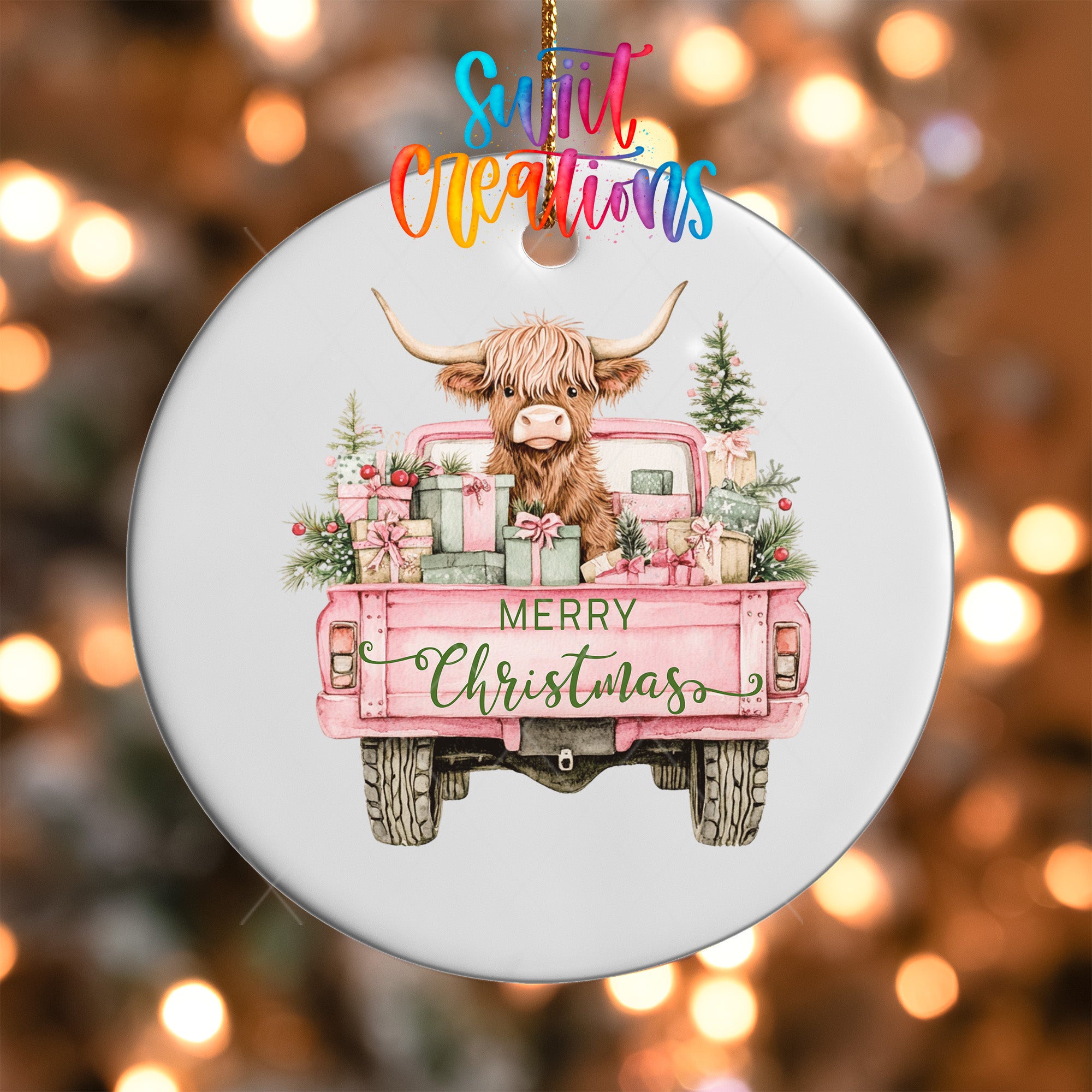 A white ornament with a pink truck and a cow with horns, surrounded by Christmas decorations, including presents and trees.