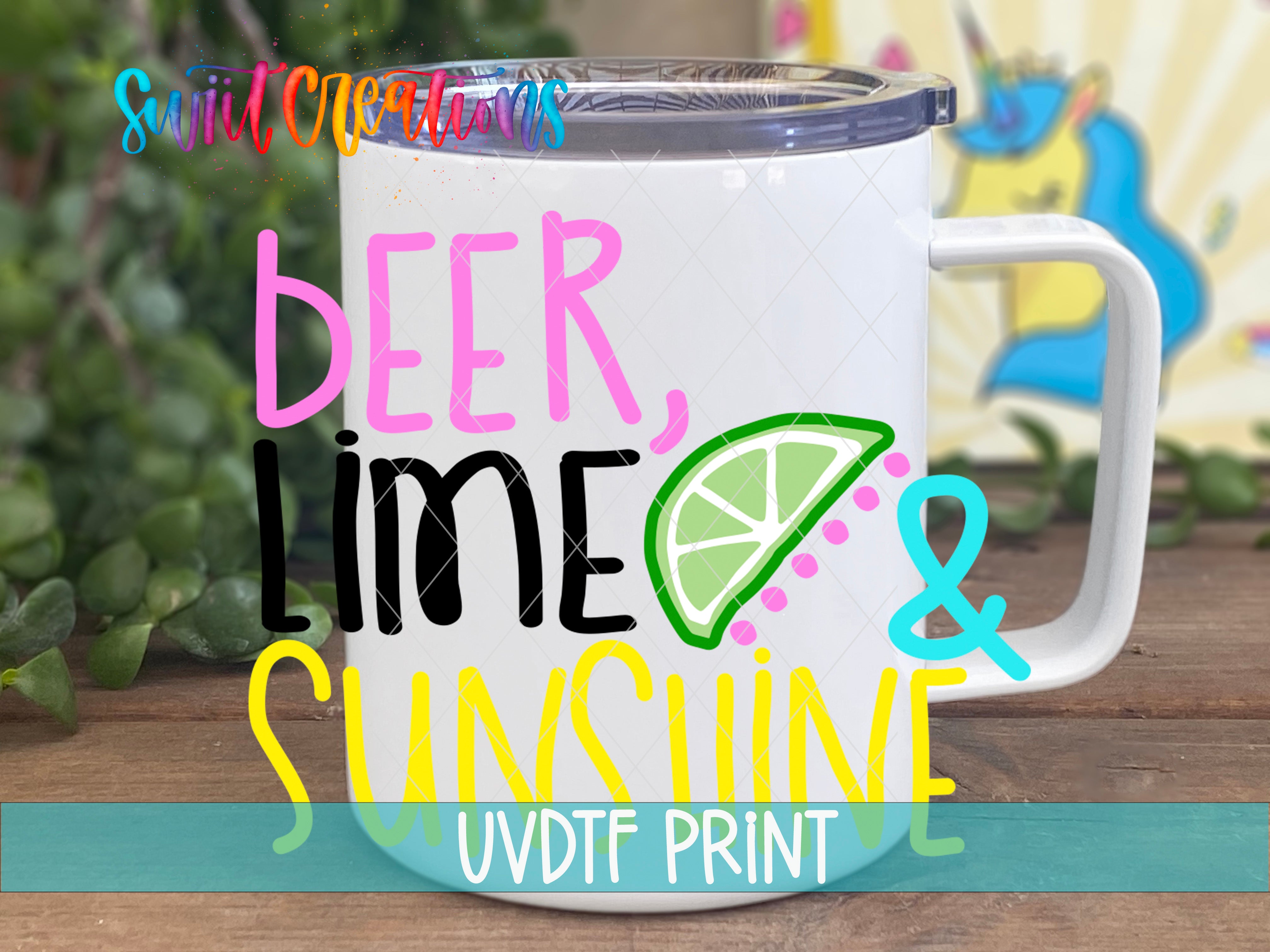 A white mug with colorful text and graphics printed on it, placed on a wooden surface with greenery in the background.