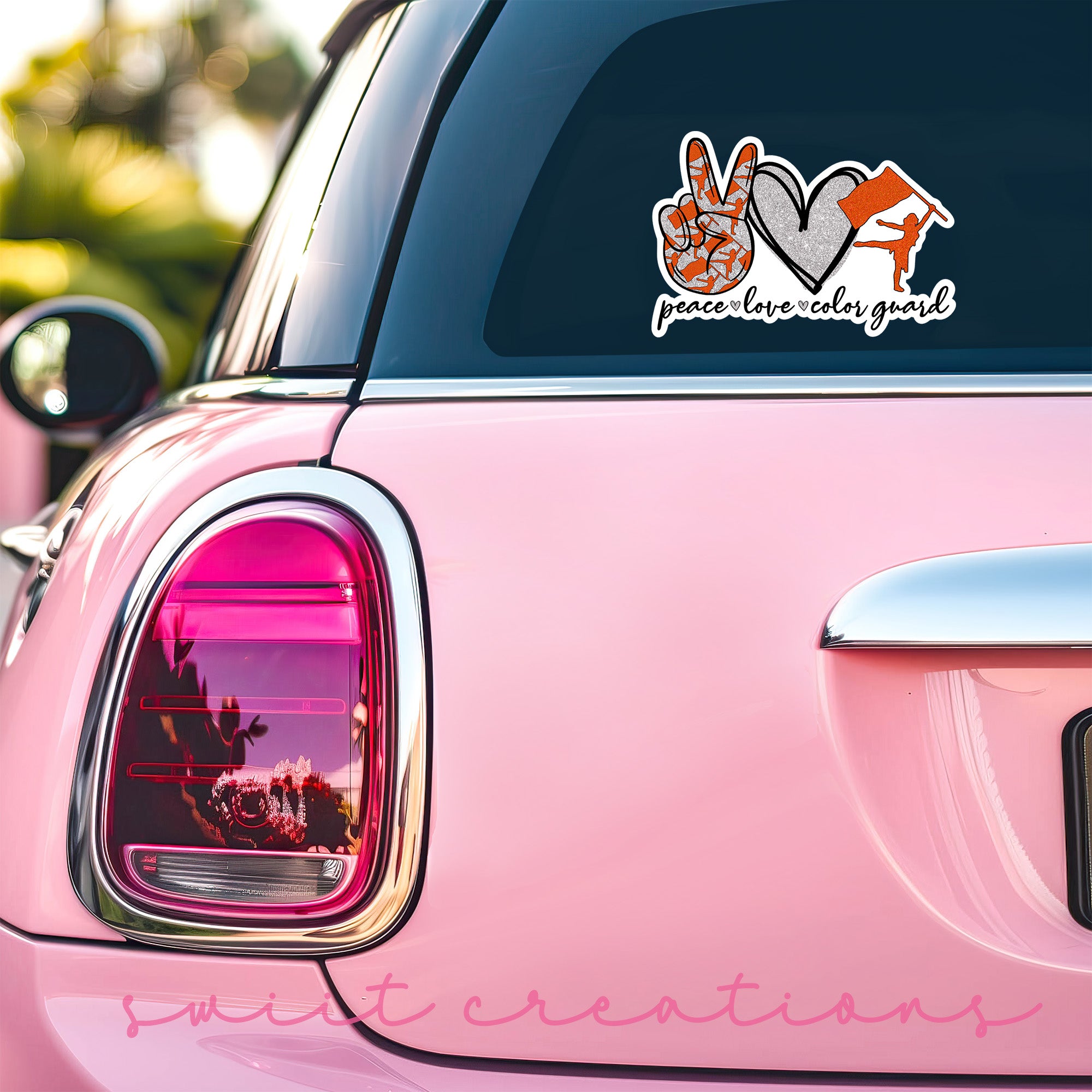 a pink car with a sticker on the back of it