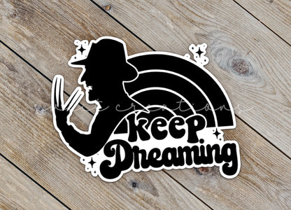 a sticker that says keep dreaming on a wooden surface
